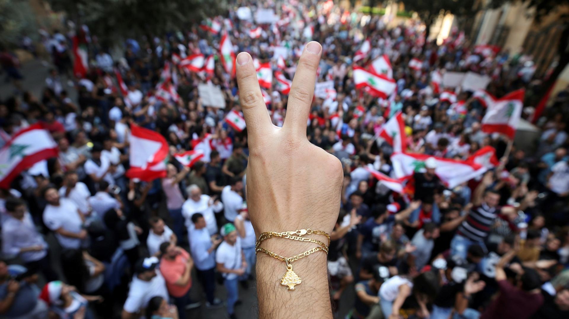 A demonstrator flashes a V sign during an anti-government protest in downtown Beirut, Lebanon October 21, 2019. 