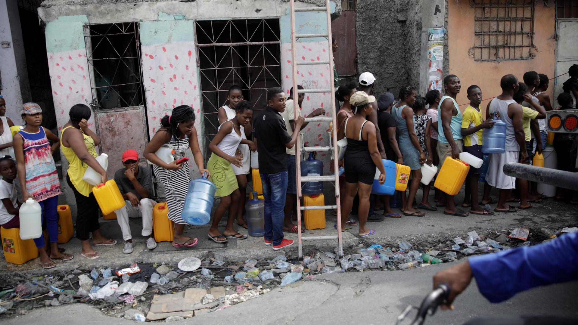 People wait in line to get water in Port-au-Prince, Haiti, on September 29, 2019. 