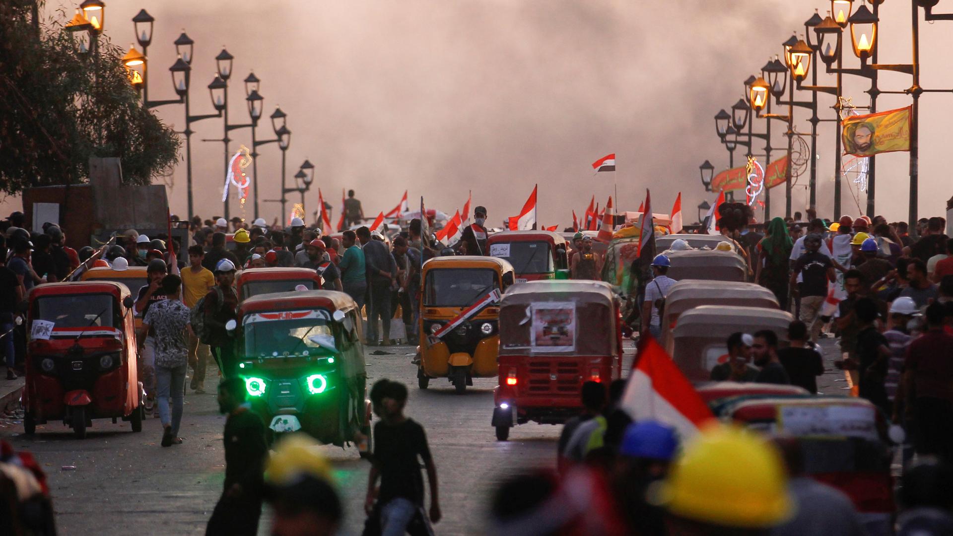 Demonstrators and tuk-tuk drivers are seen on a bridge during ongoing anti-government protests, in Baghdad, Iraq, on Nov. 4, 2019.
