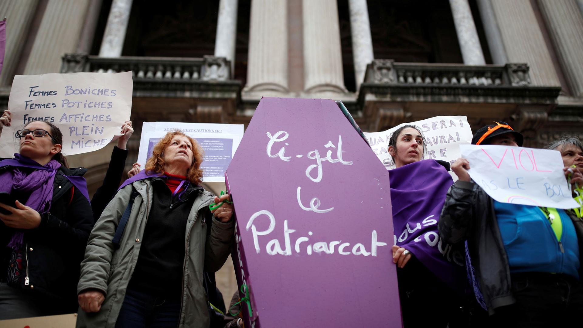 Women hold a coffin prop during a demonstration to protest femicide and violence against women in Paris.