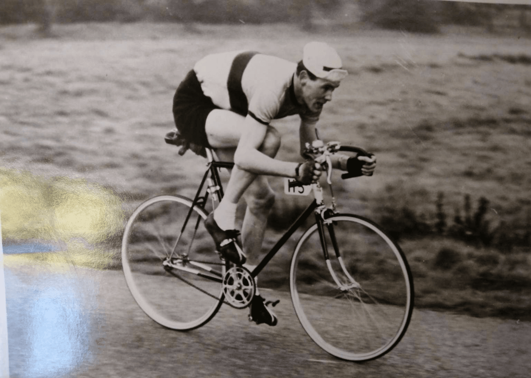 A man on a bicycle on a black and white photo.