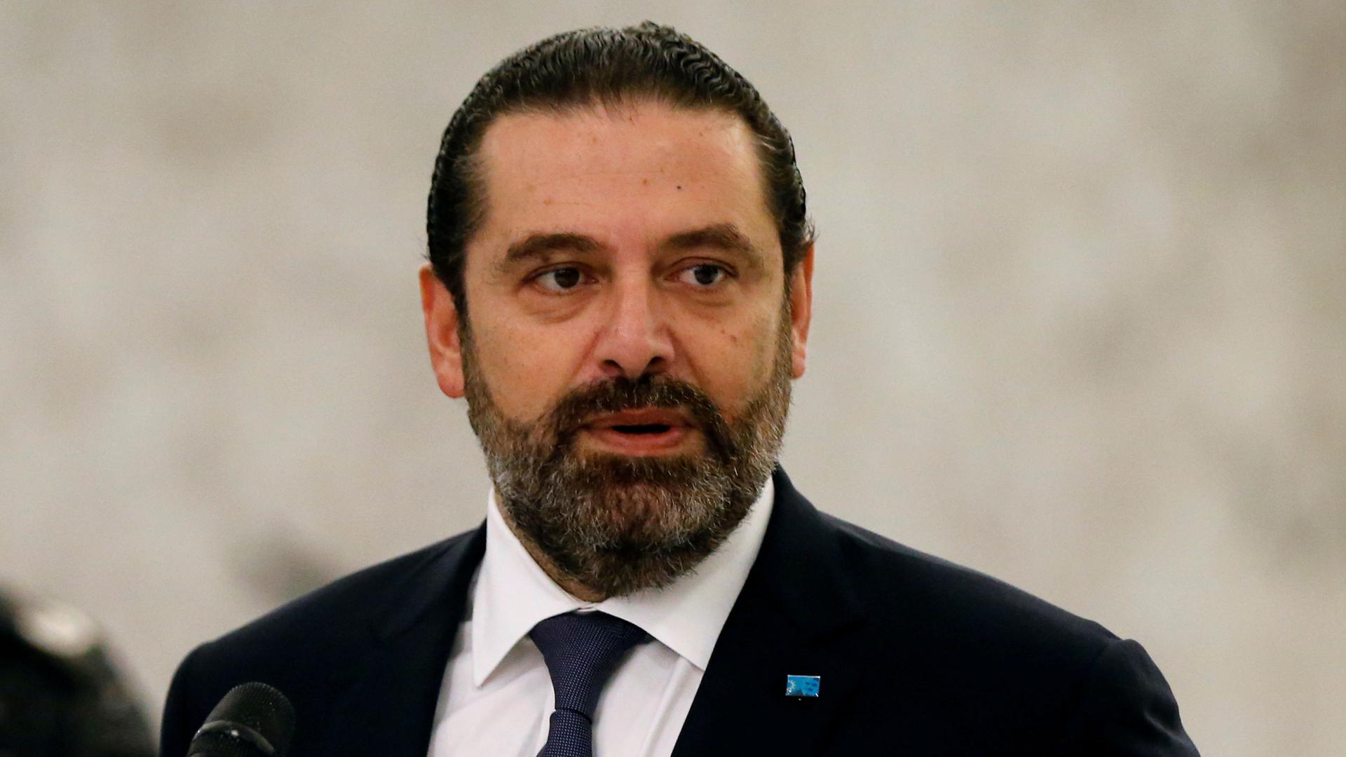 Lebanon's caretaker Prime Minister Saad al-Hariri is shown in a close-up photo standing behind a microphone and wearing a dark suit.