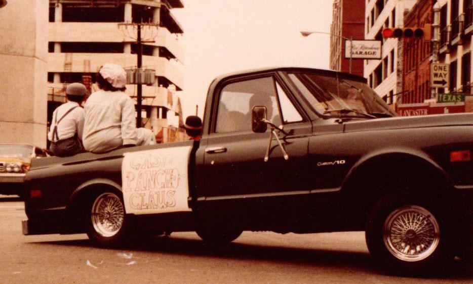 A pickup truck is shown with three people sitting in the back.