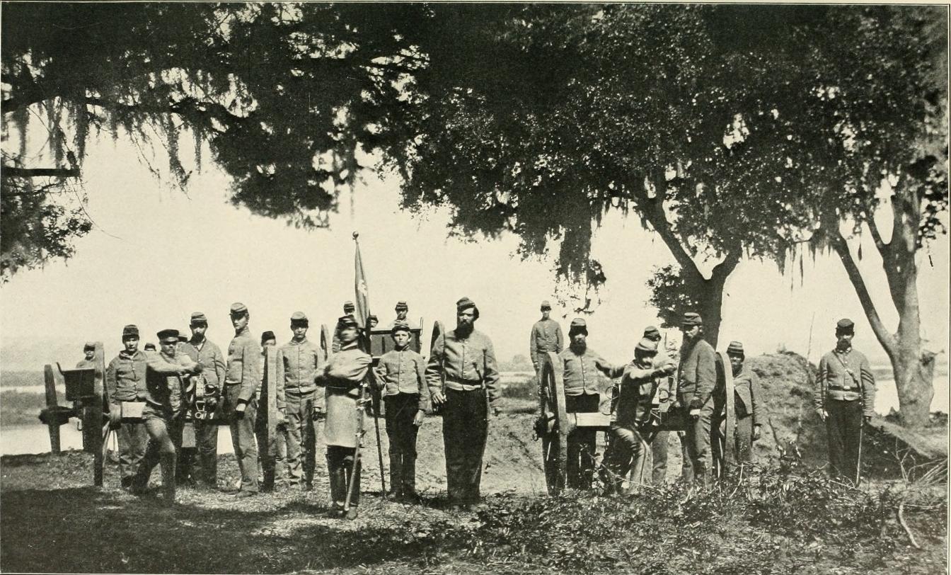 A group of military men stand in a line with their weapons. 