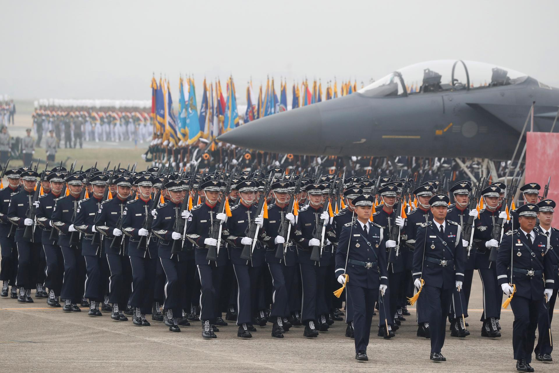 South Korean Army soldiers in black uniforms participate in a ceremony to mark the 71st anniversary of Armed Forces Day near military plane