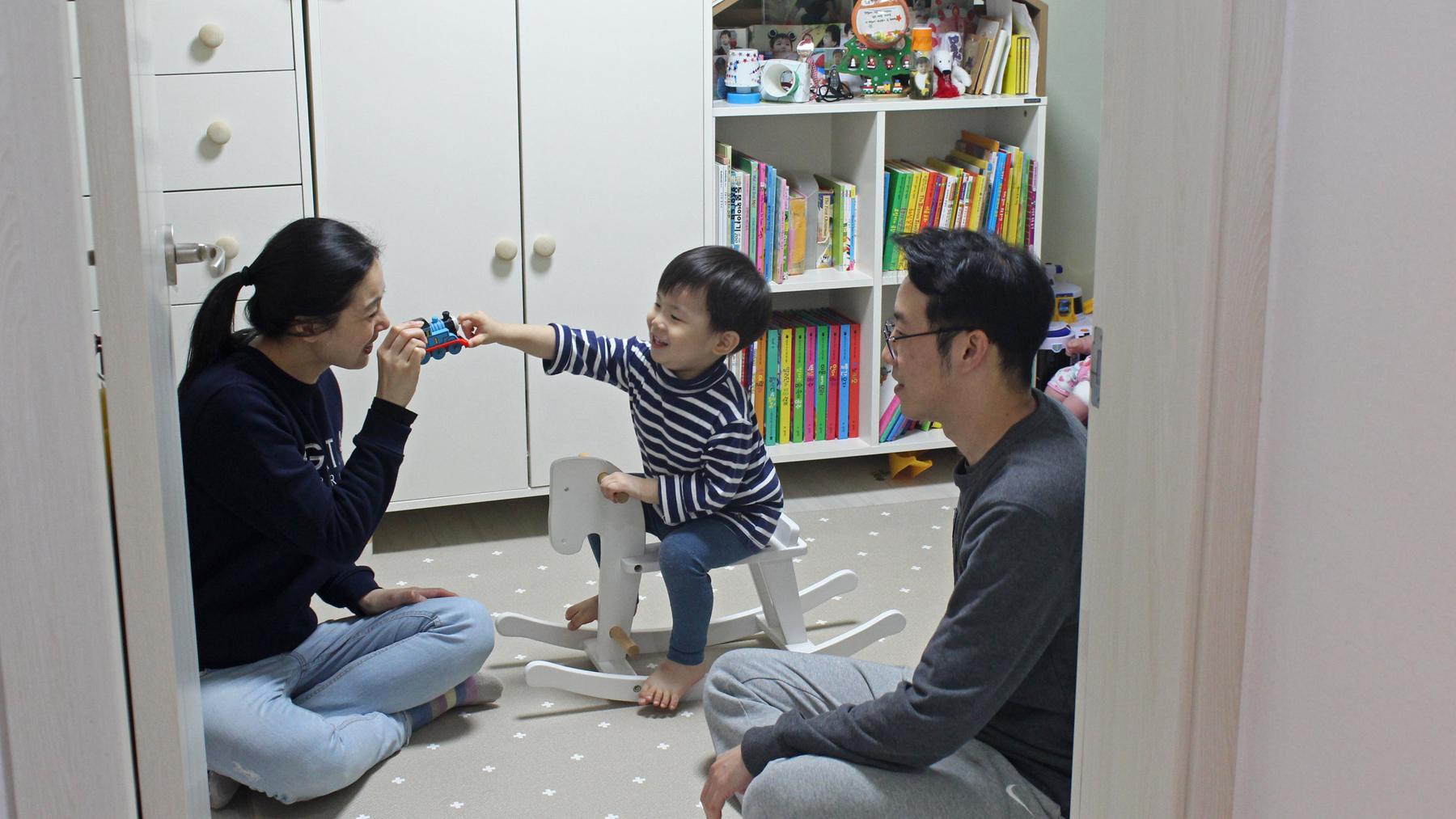 Seo Ji-hye and Cho Sung-won watch as their two-year-old son, Han-sol, plays with a toy train in his bedroom in Seoul.