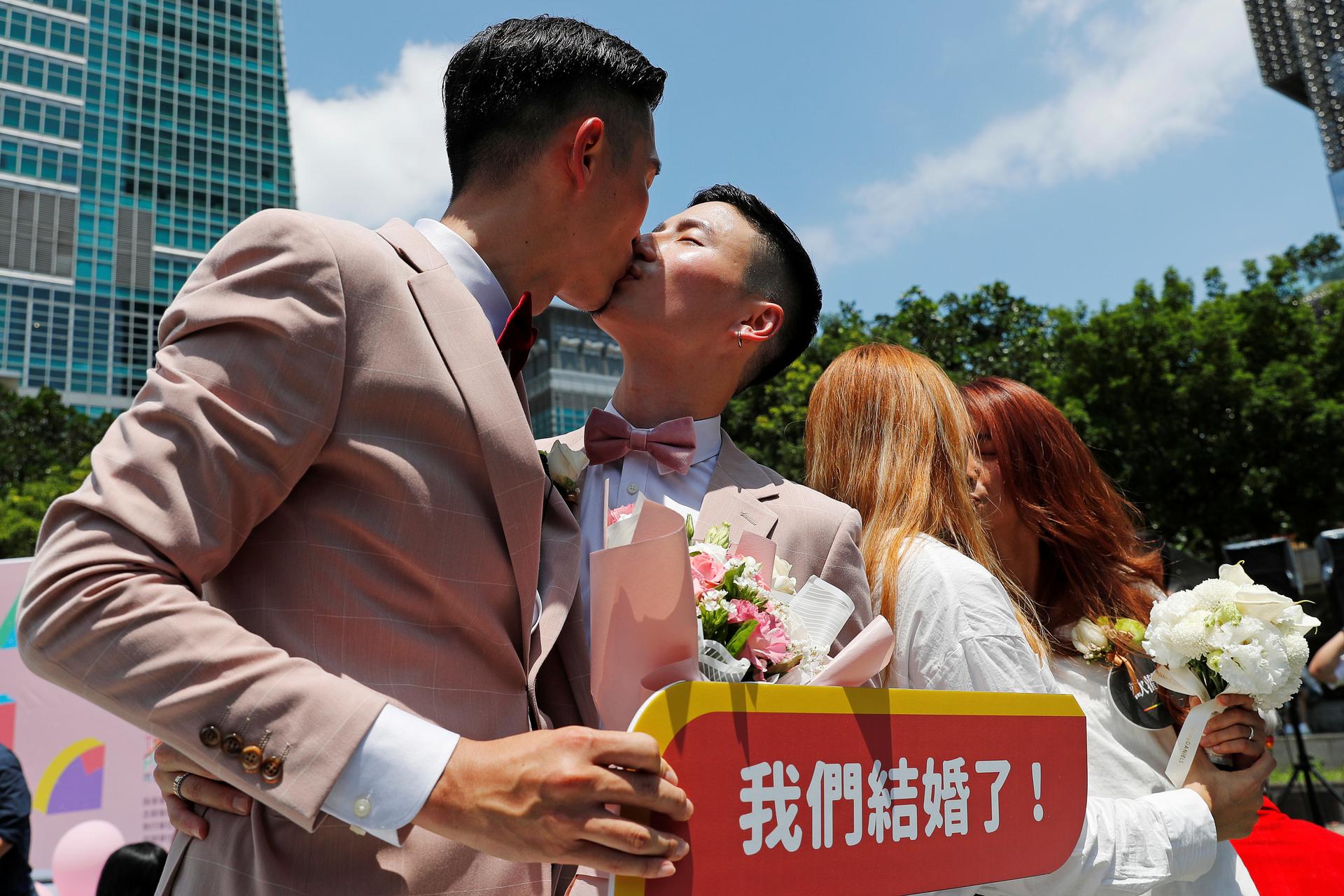 Gay and lesbian newlyweds kiss at a pro same-sex marriage party in Taipei.