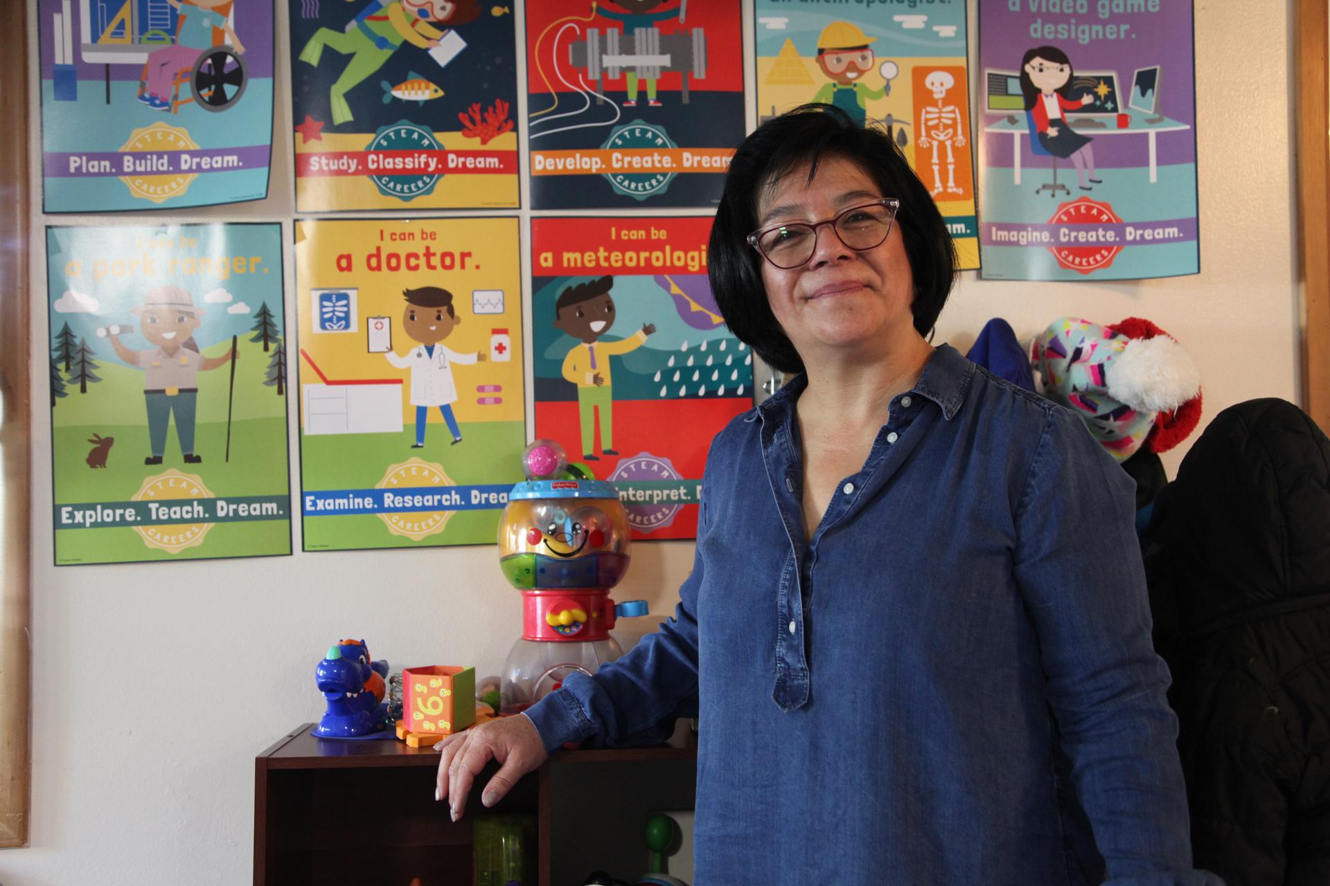 A woman stands in front of children's posters