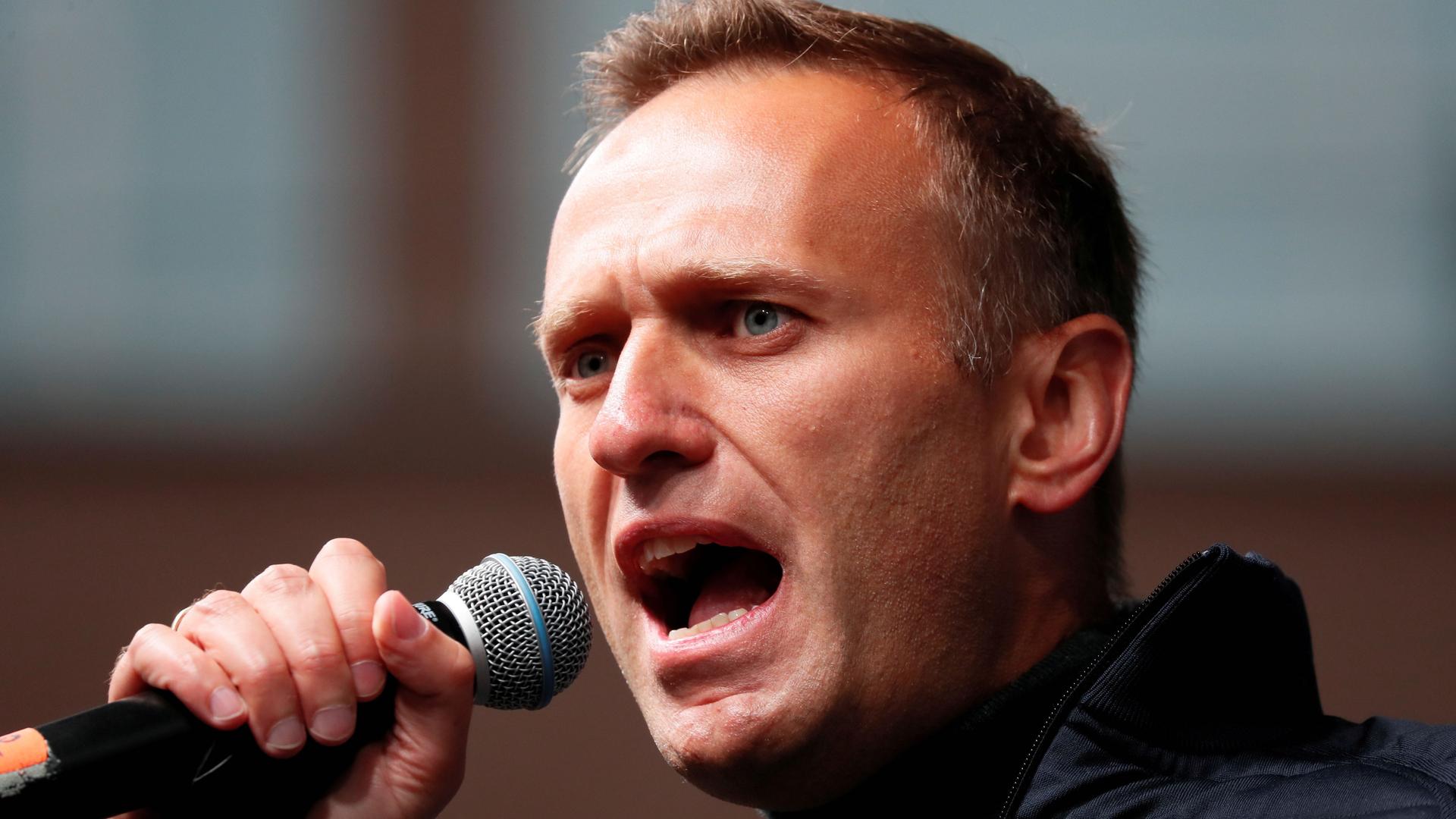 Navalny holds a microphone and speaks