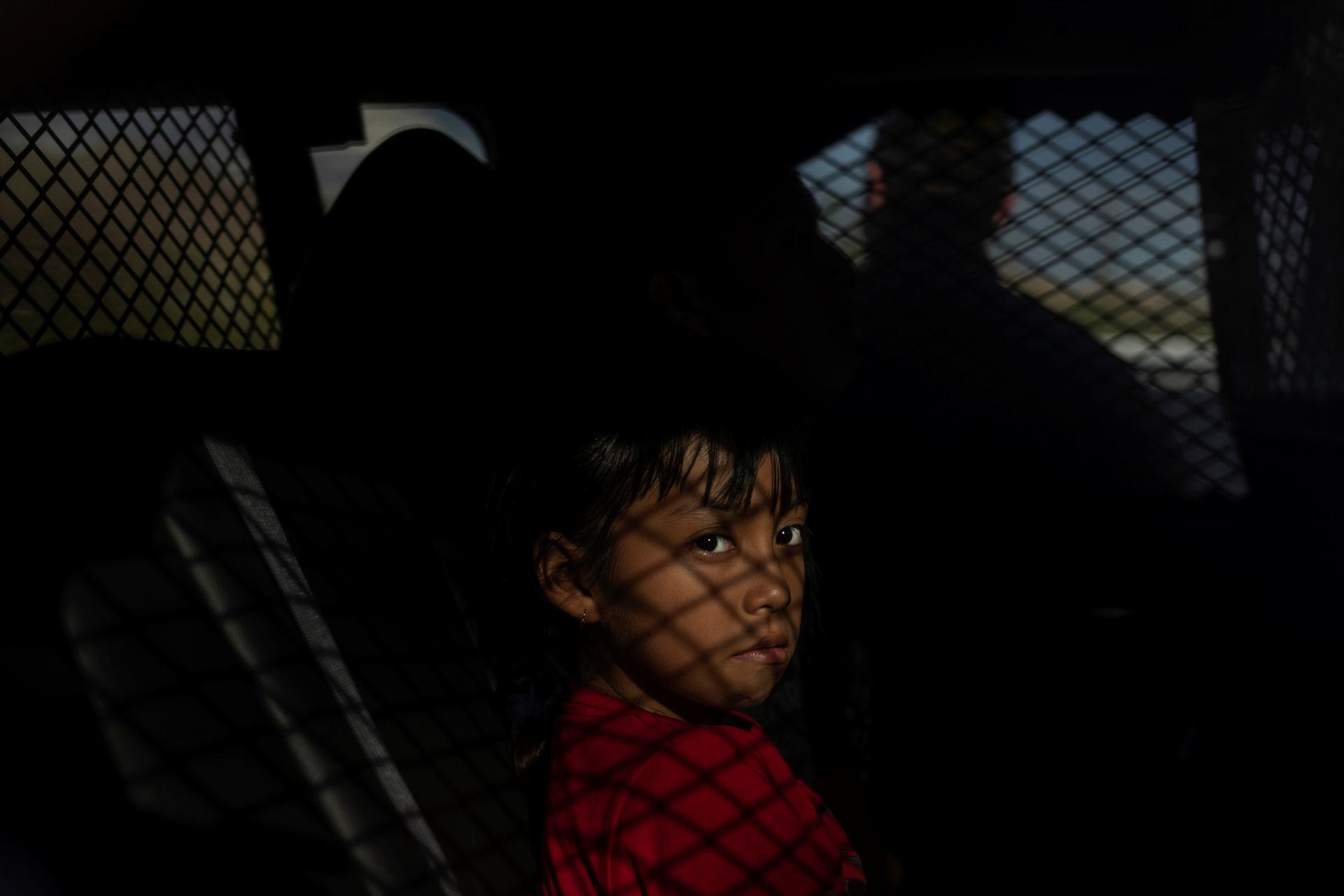 A 9-year-old migrant girl from Guatemala sits in the back of a US Border Patrol vehicle after she was apprehended for crossing the border from Mexico in Sunland Park, New Mexico, on June 14, 2018.