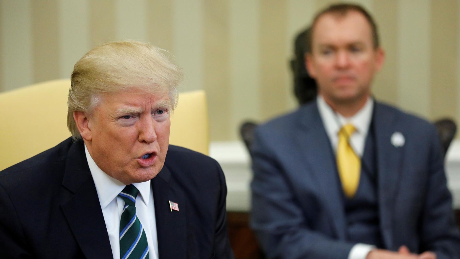 Office of Management and Budget (OMB) Director Mick Mulvaney (R) listens as President Donald Trump (L) meets with members of the Republican Study Committee