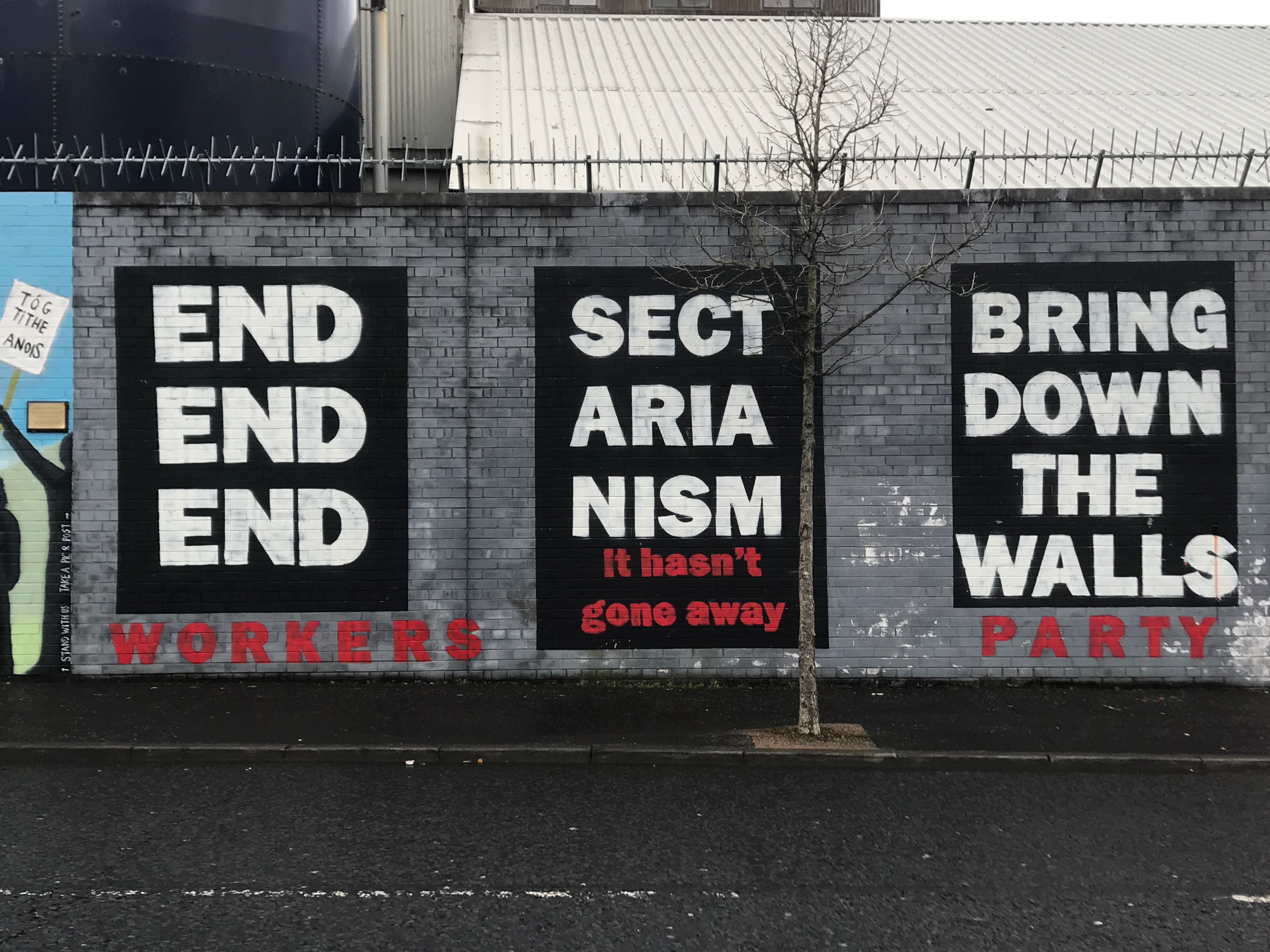 A mural shows messages related to ending sectarianism and taking down walls in Belfast, Northern Ireland.