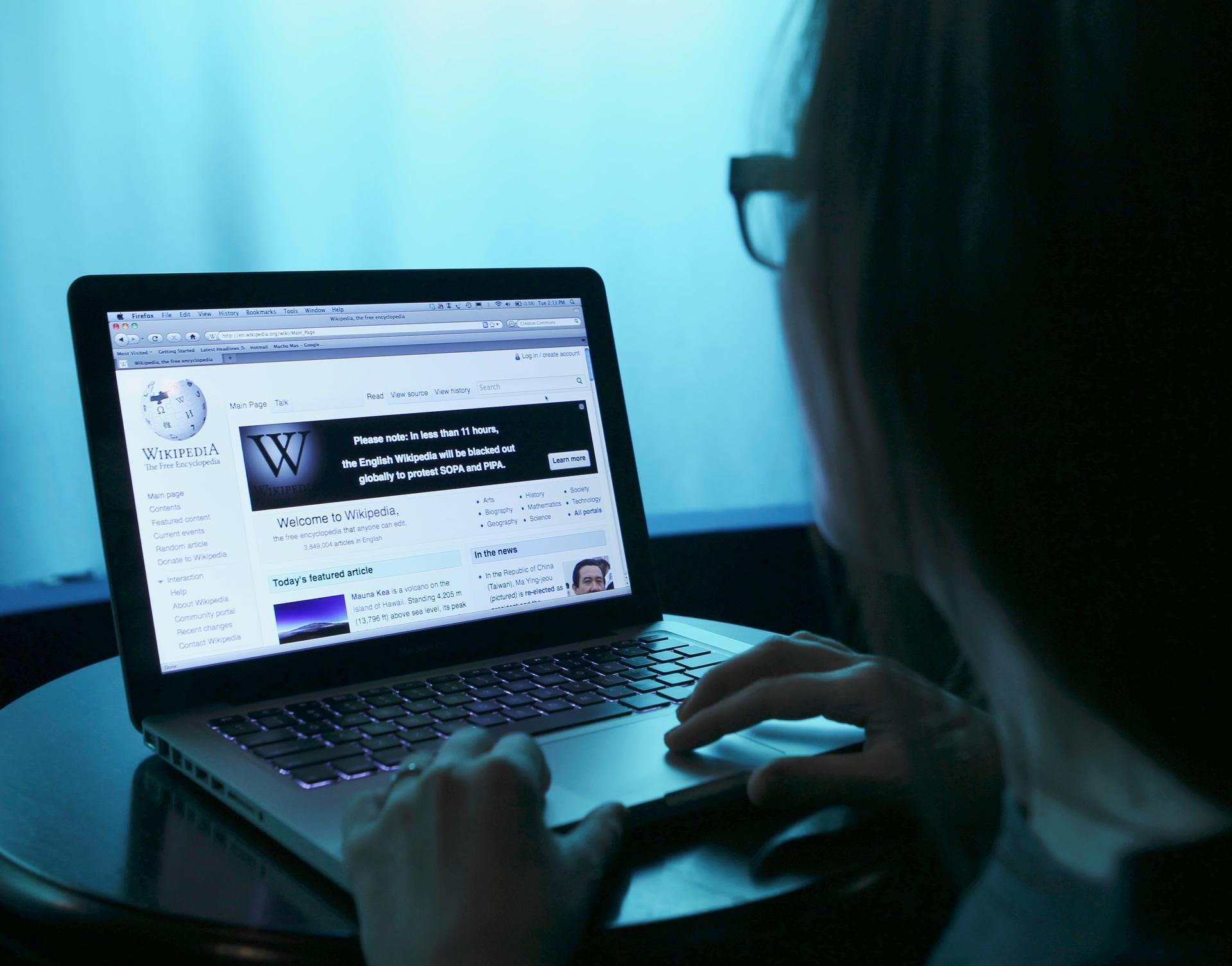 A woman uses Wikipedia on a laptop.
