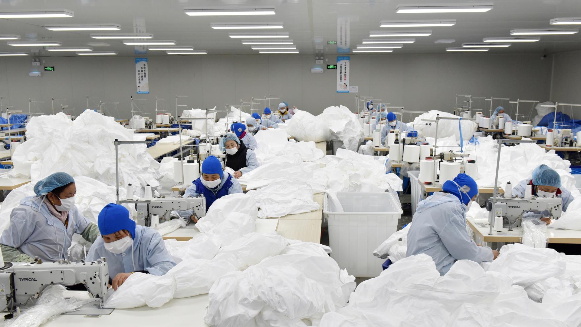 Workers make protective suits at a factory, as the country is hit by an epidemic of the new coronavirus, in Chaohu, Anhui province, China.