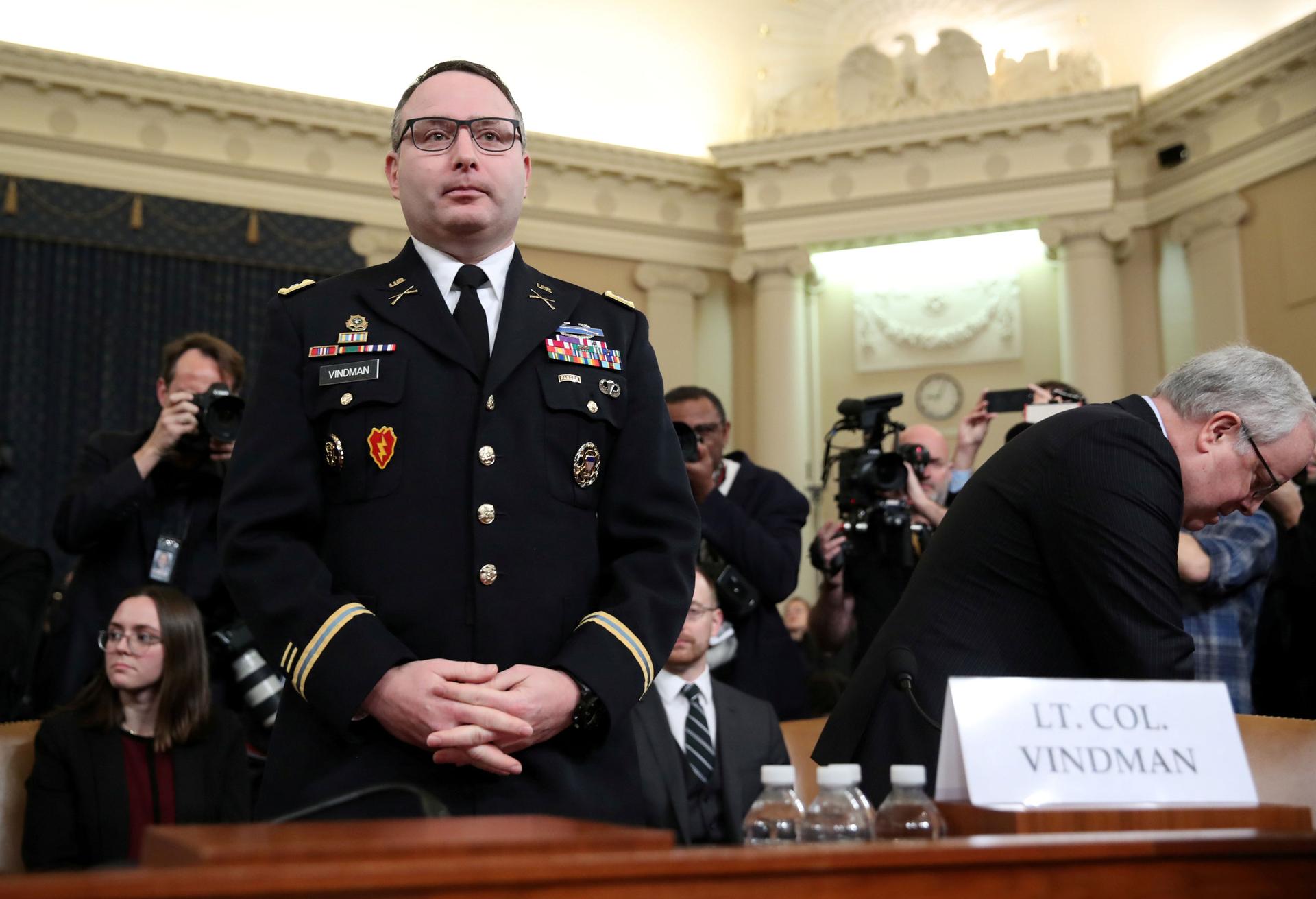 A man in uniform stands behind a desk