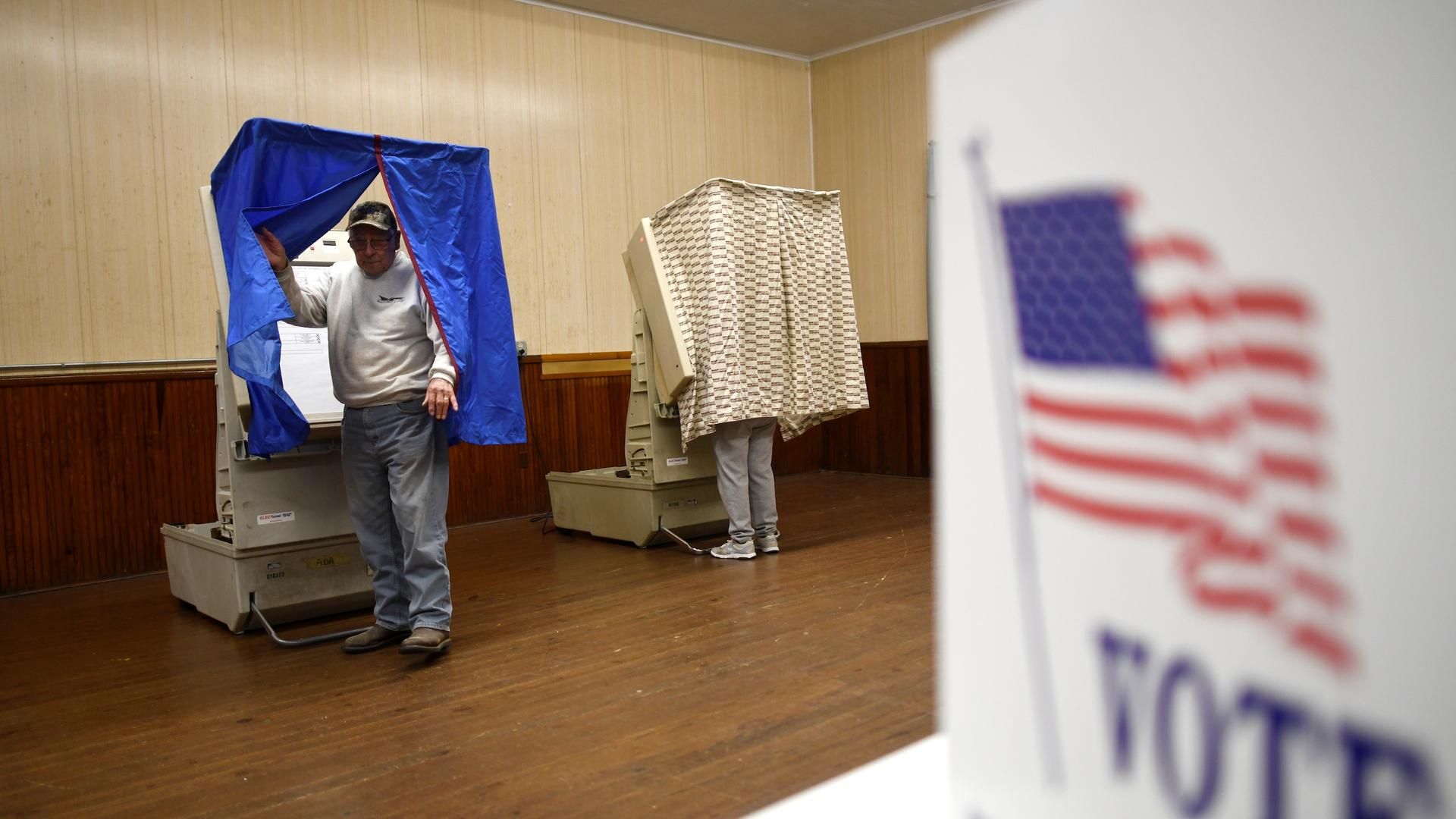 A man leaves a voting booth 
