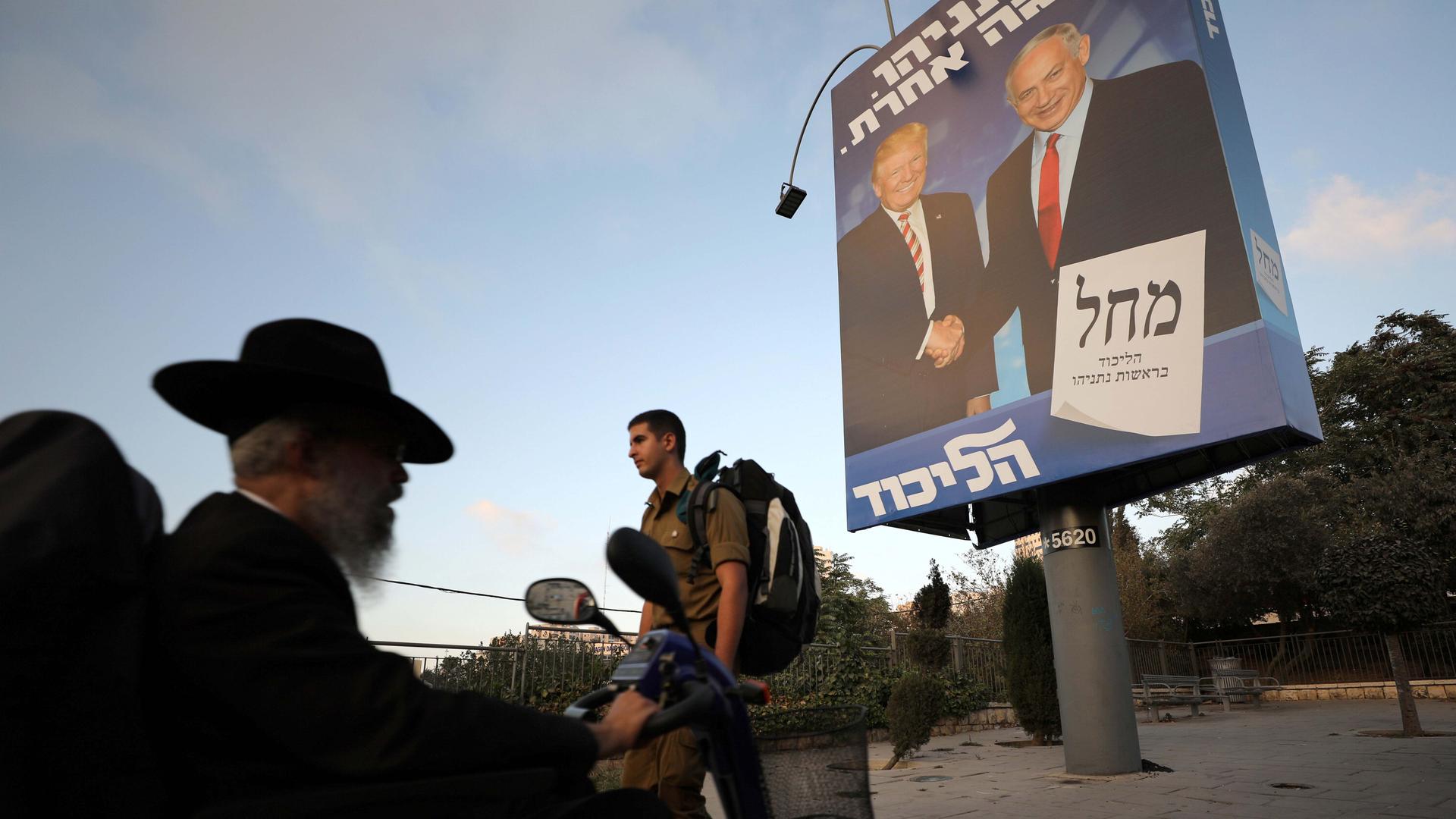 Ultra-Orthodox Jewish men walk past a Likud party election campaign banner depicting Israeli Prime Minister Benjamin Netanyahu and U.S. President Donald Trump in Jerusalem September 11, 2019.