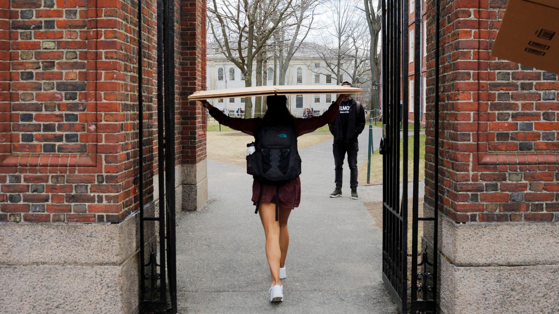 A student carries a box to her dorm at Harvard University