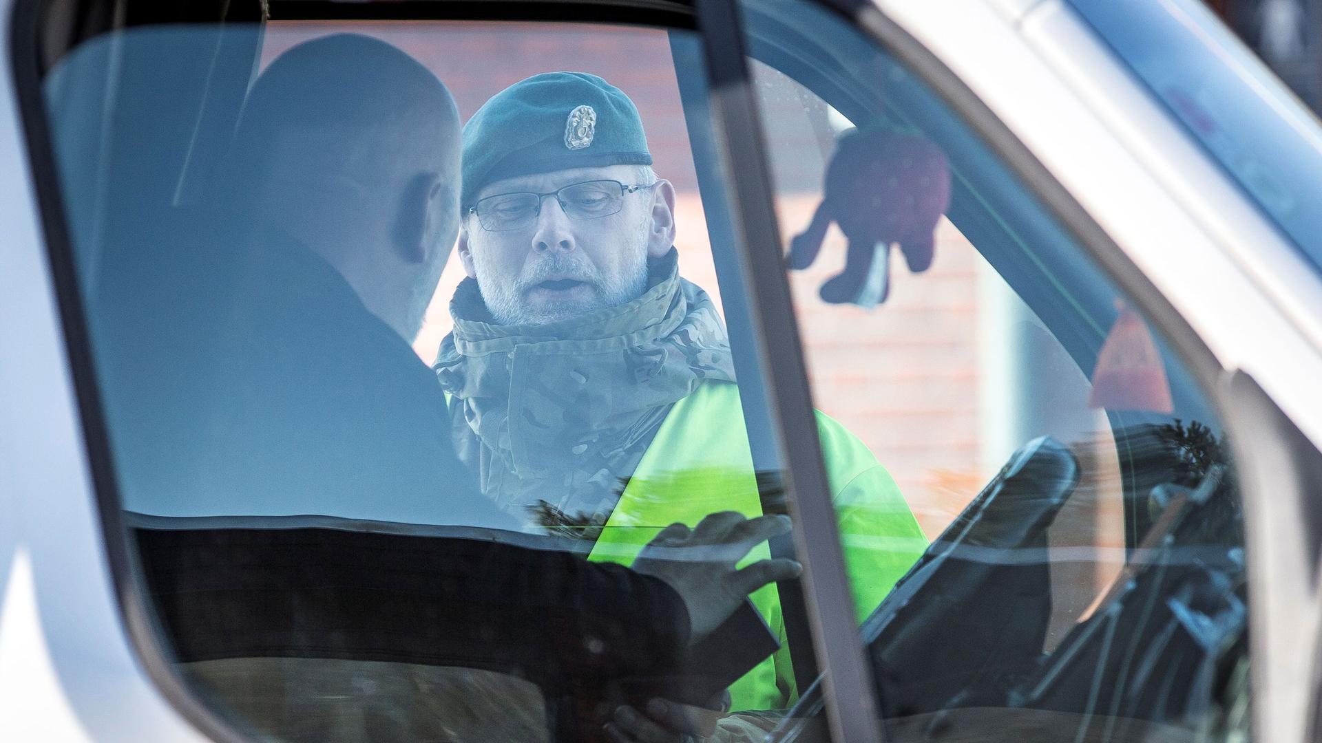 A police officer checks a driver at the Danish border in Rodby, Denmark, March 14, 2020.