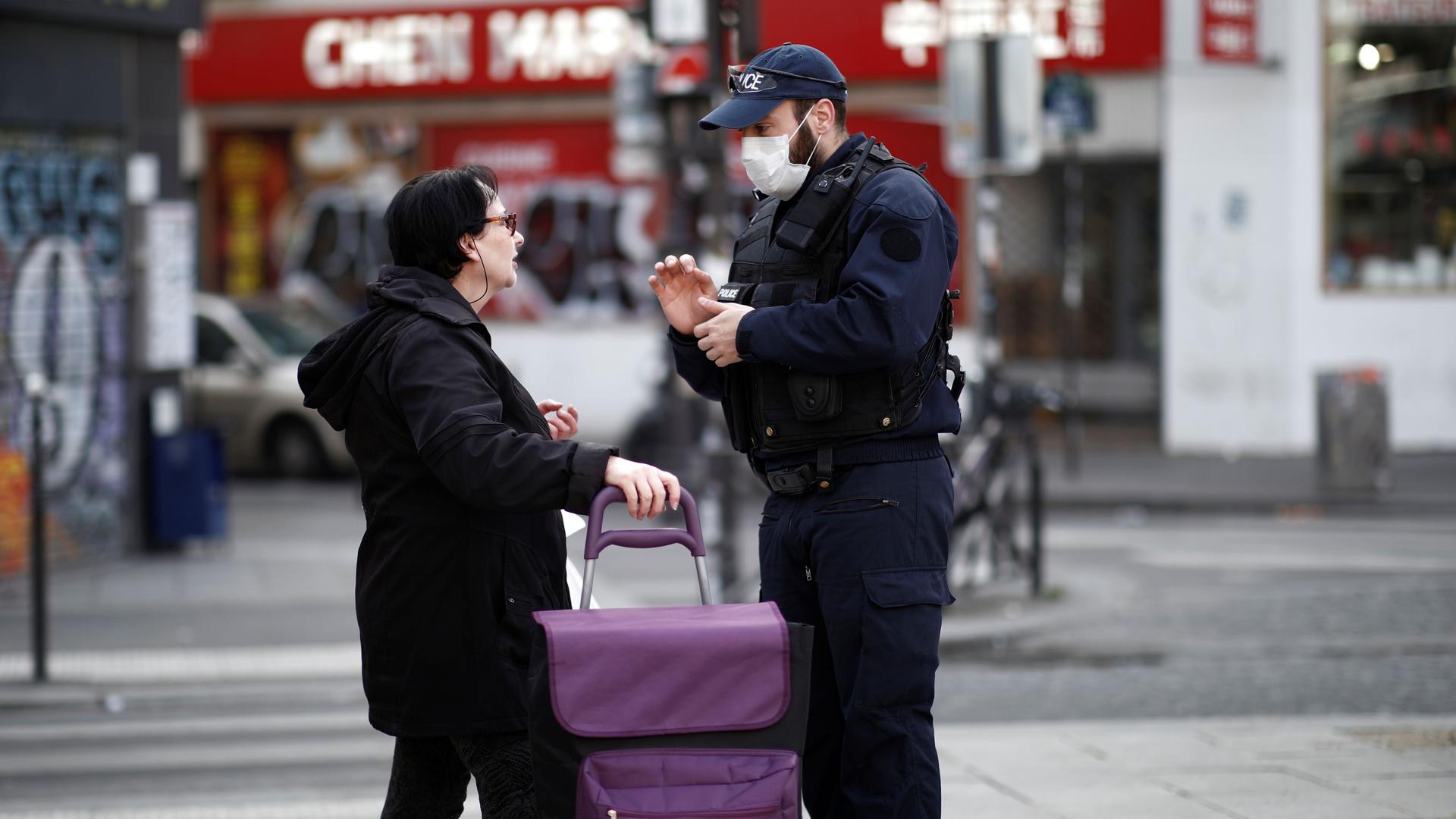 A French police officer controls a bystander in Belleville neighborhood as a lockdown imposed to slow the rate of the coronavirus disease (COVID-19) contagion started midday March 17. 