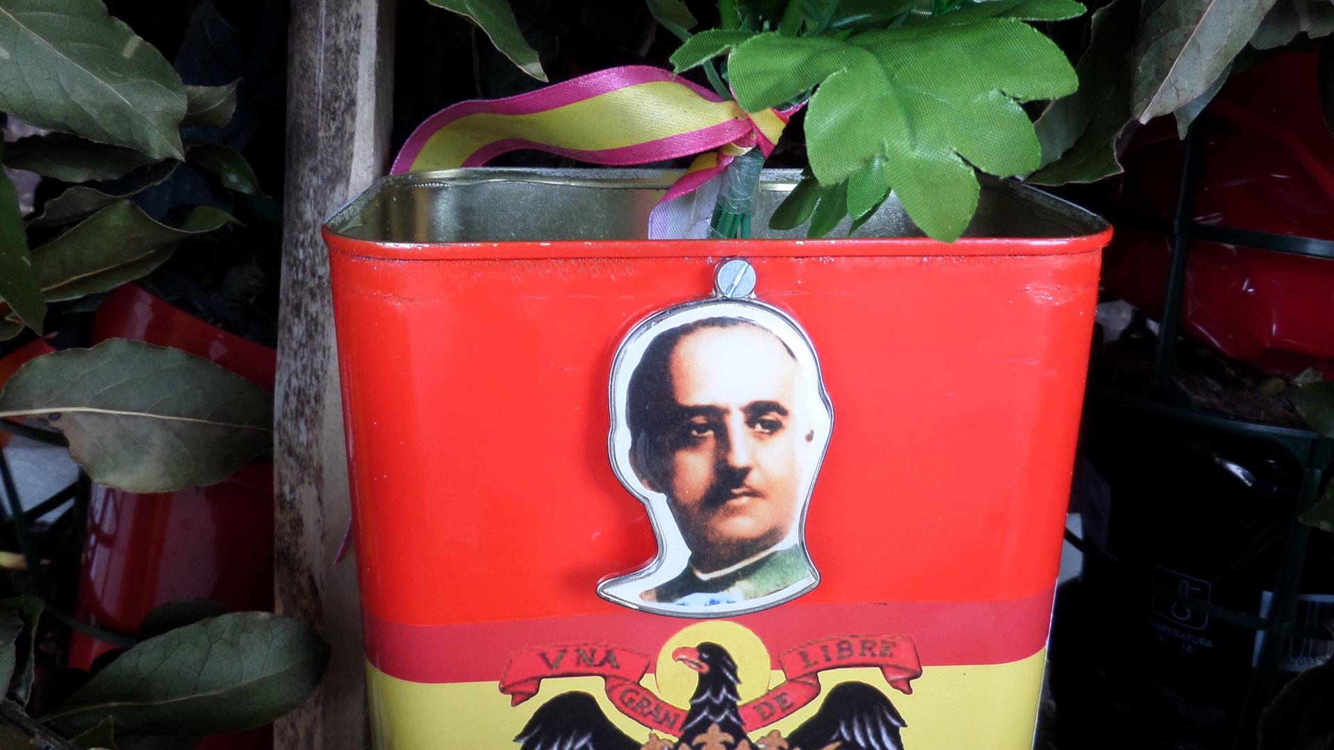 General Franco's face on the side of a red flower pot at his grave. 