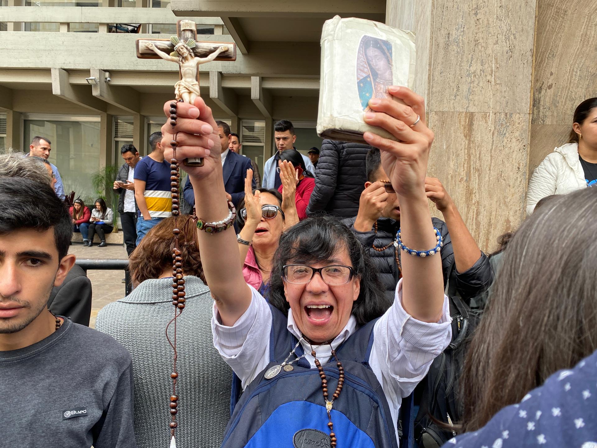 A demonstrator displays her bible and crucifix during a protest outside Colombia's constitutional court.