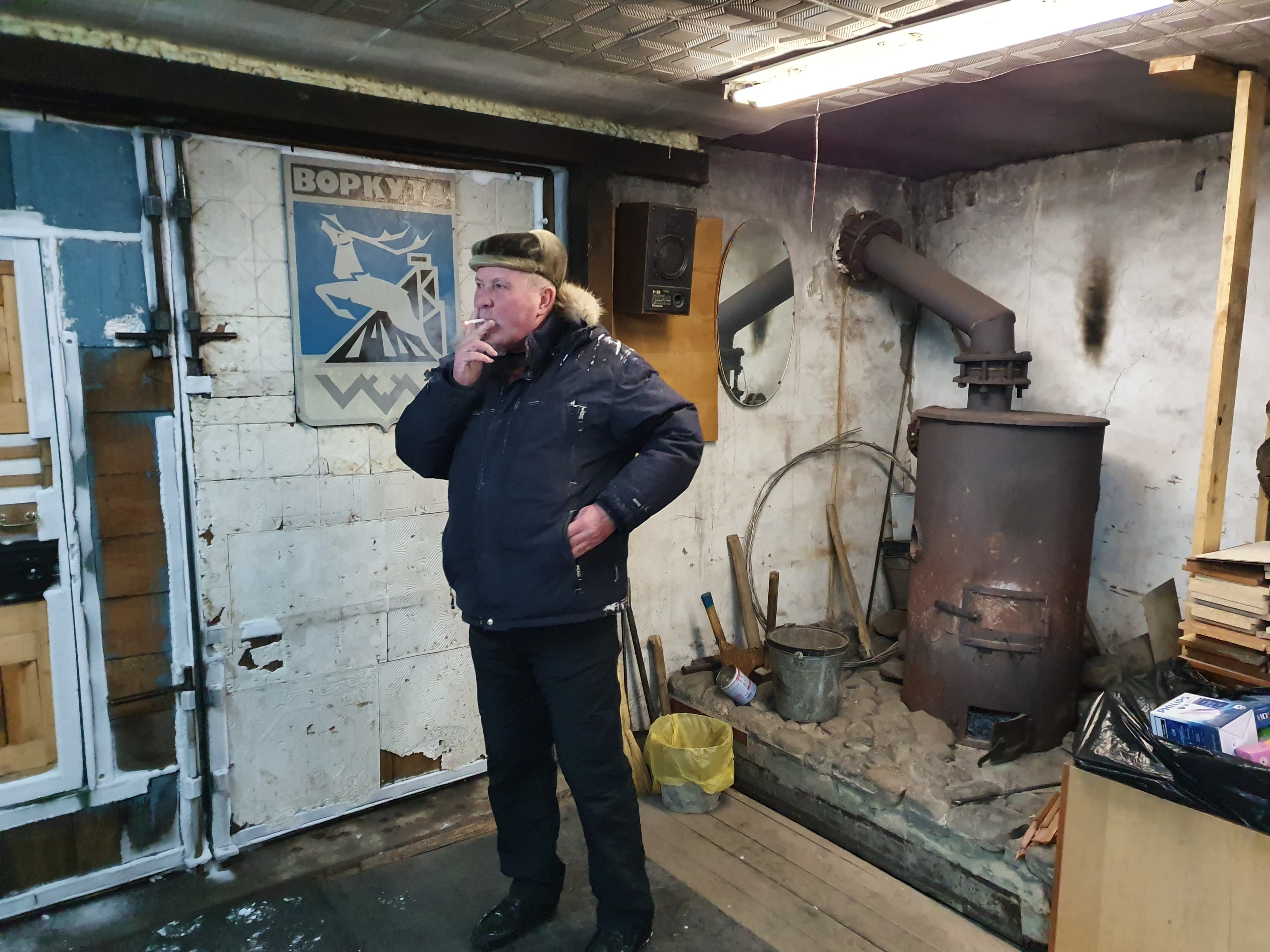 A man stands smoking a cigarette