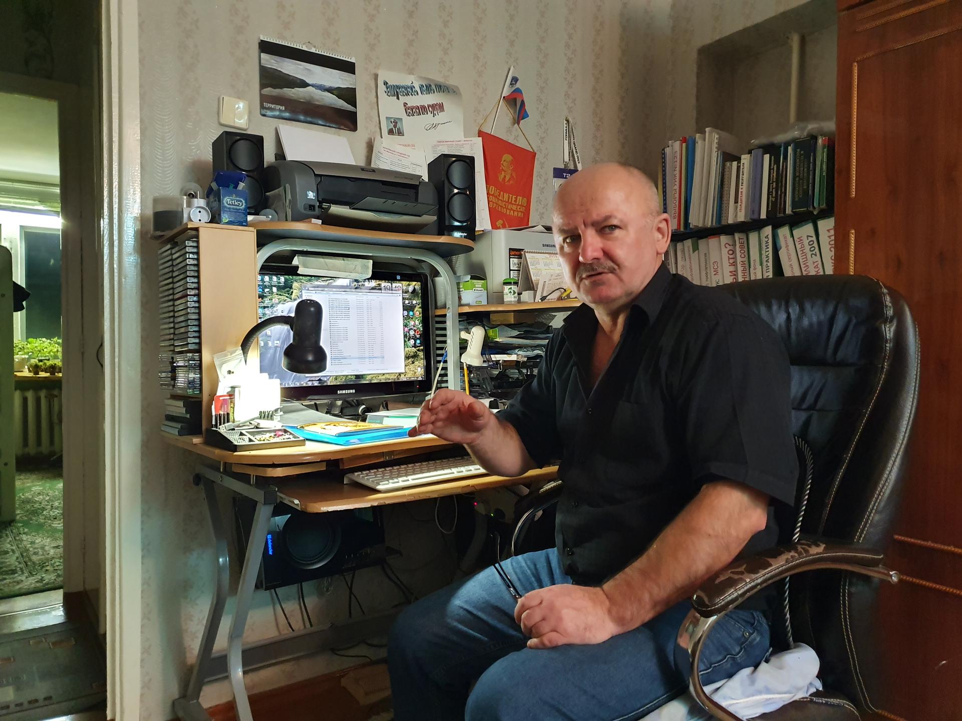 A bald man sits at a desk