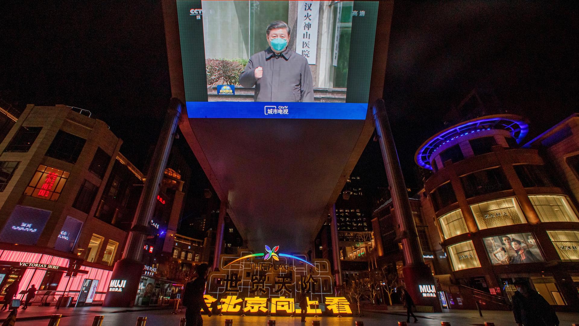 A screen shows a CCTV state media broadcast of Chinese President Xi Jinping's visit to Wuhan at a shopping centre in Beijing as the country is hit by the outbreak of the novel coronavirus, China, March 10, 2020. 
