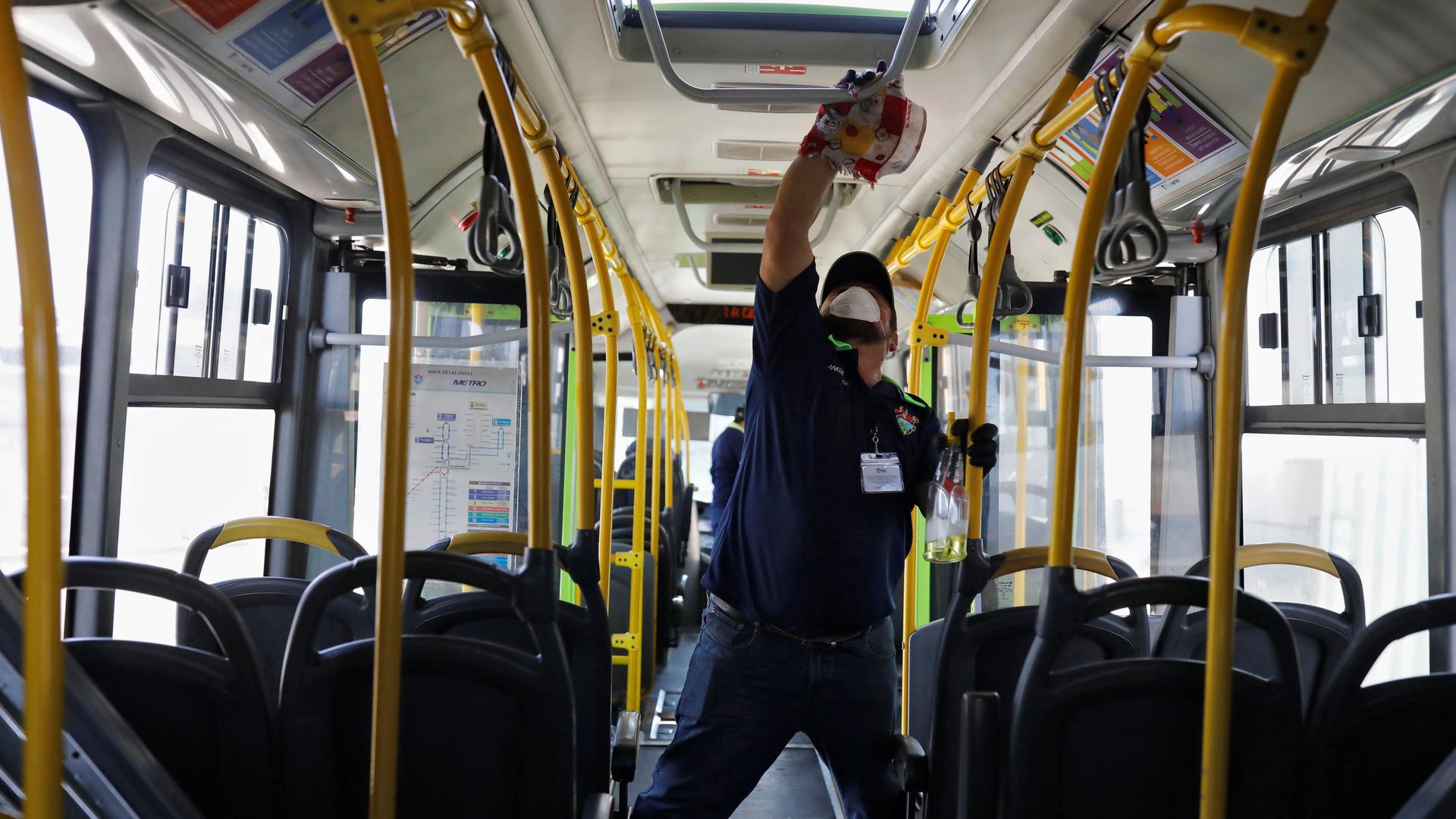 A worker wears a protective face mask works while cleaning the interior of a public bus, amid concerns over the spread of coronavirus disease (COVID-19), in Guatemala City, Guatemala, March 15, 2020. 