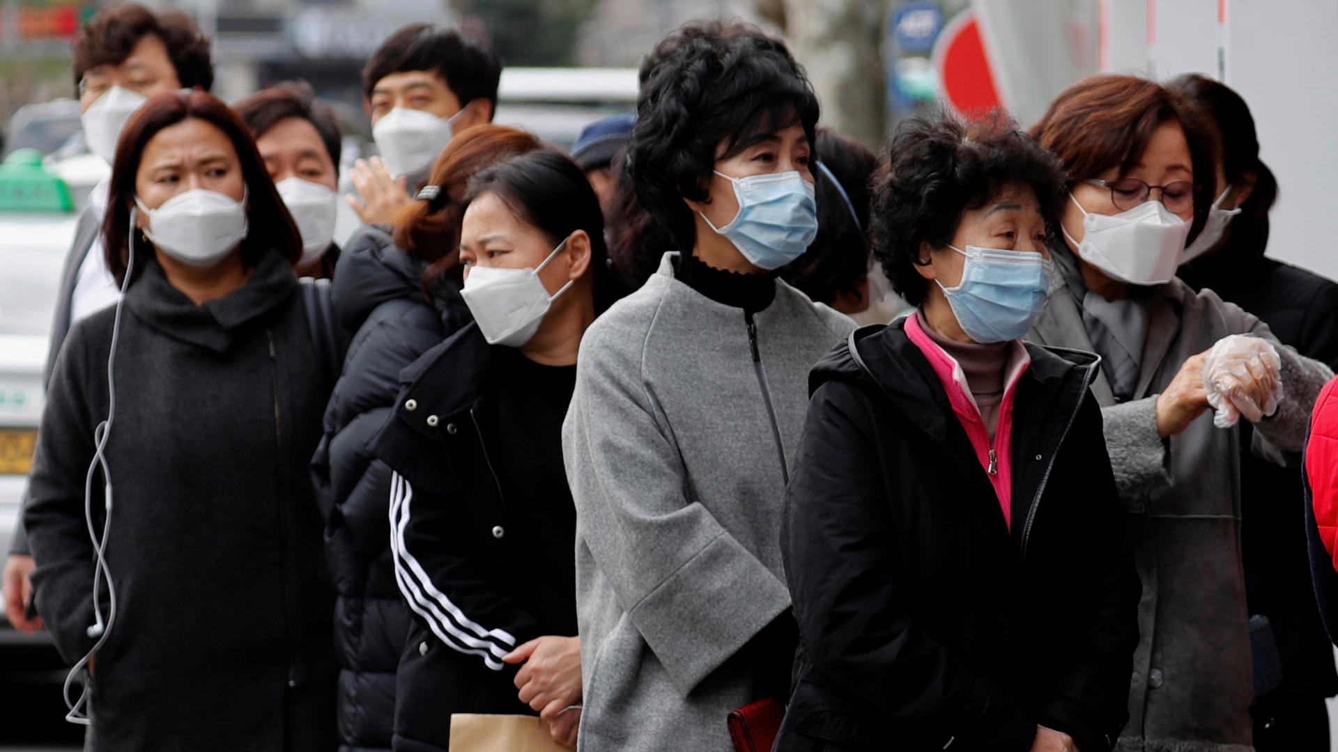 People wearing masks stand in a line to buy face masks in front of a drug store amid the rise in confirmed cases of the novel coronavirus disease of COVID-19 in Daegu, South Korea, March 3, 2020. 