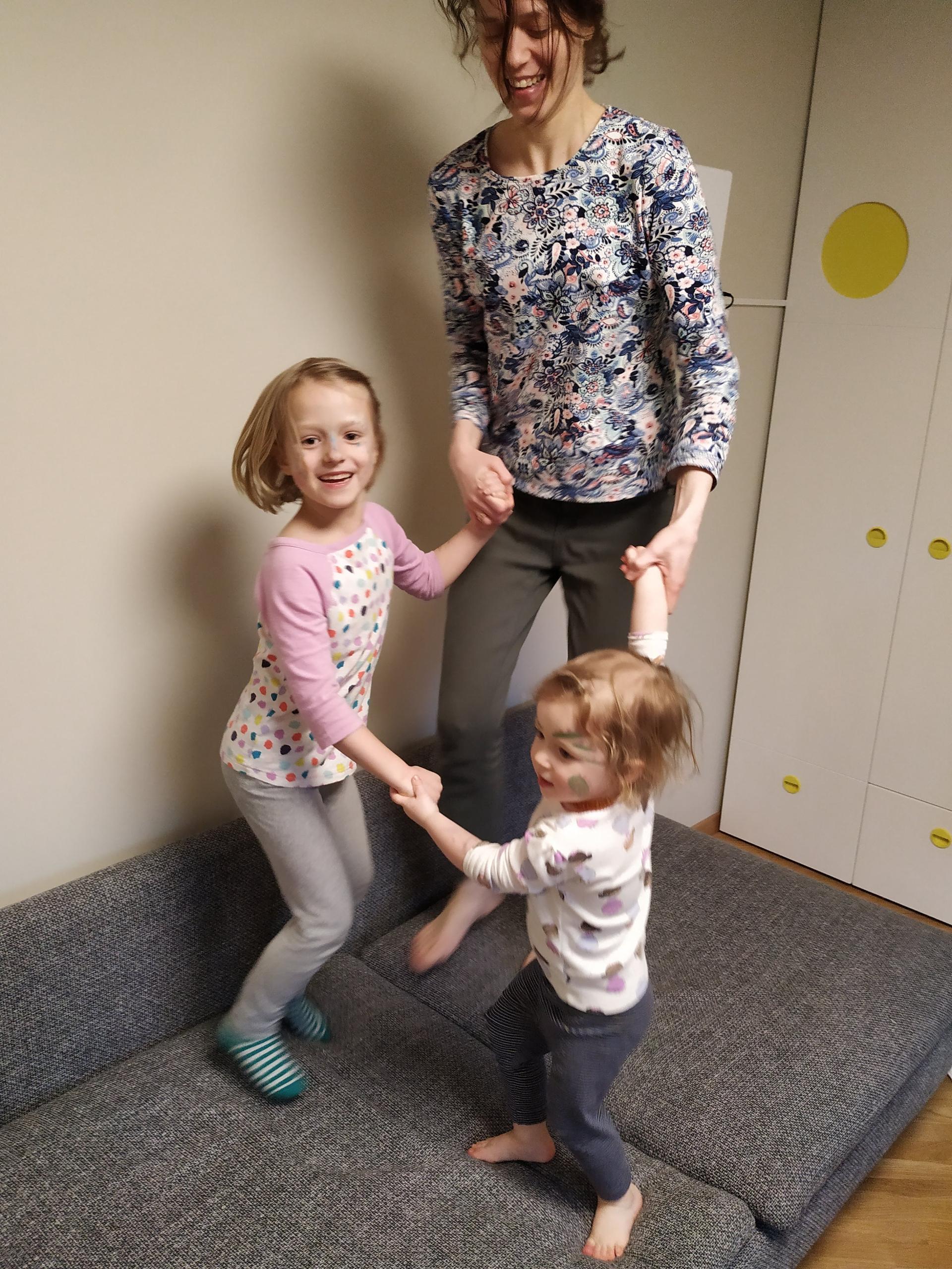 Eglė Merkyte holds an impromptu dance party on their couch in Lithuania with her daughters, Unė and Bruknė Kubiliūtė.