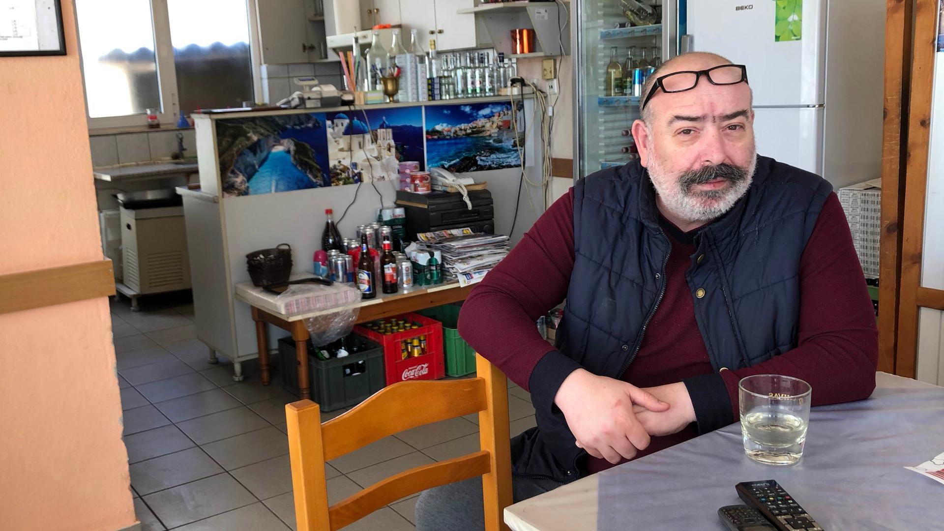Stelios Panagos sits at his cafe in Kastanies. On a typical day, the cafe is filled with local Greeks as well as Turks. 