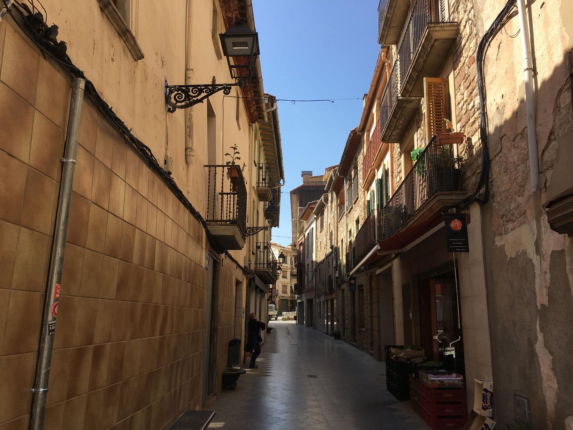 A pedestrian on a nearly deserted street in Moia, Spain.