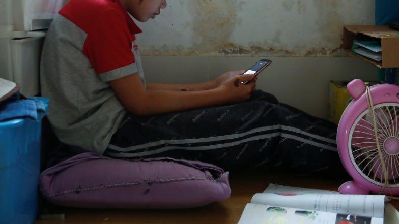 Secondary school student Wendy attends an online class with a smartphone at home during the novel coronavirus disease (COVID-19) outbreak, in Hong Kong, China, March 16, 2020. 
