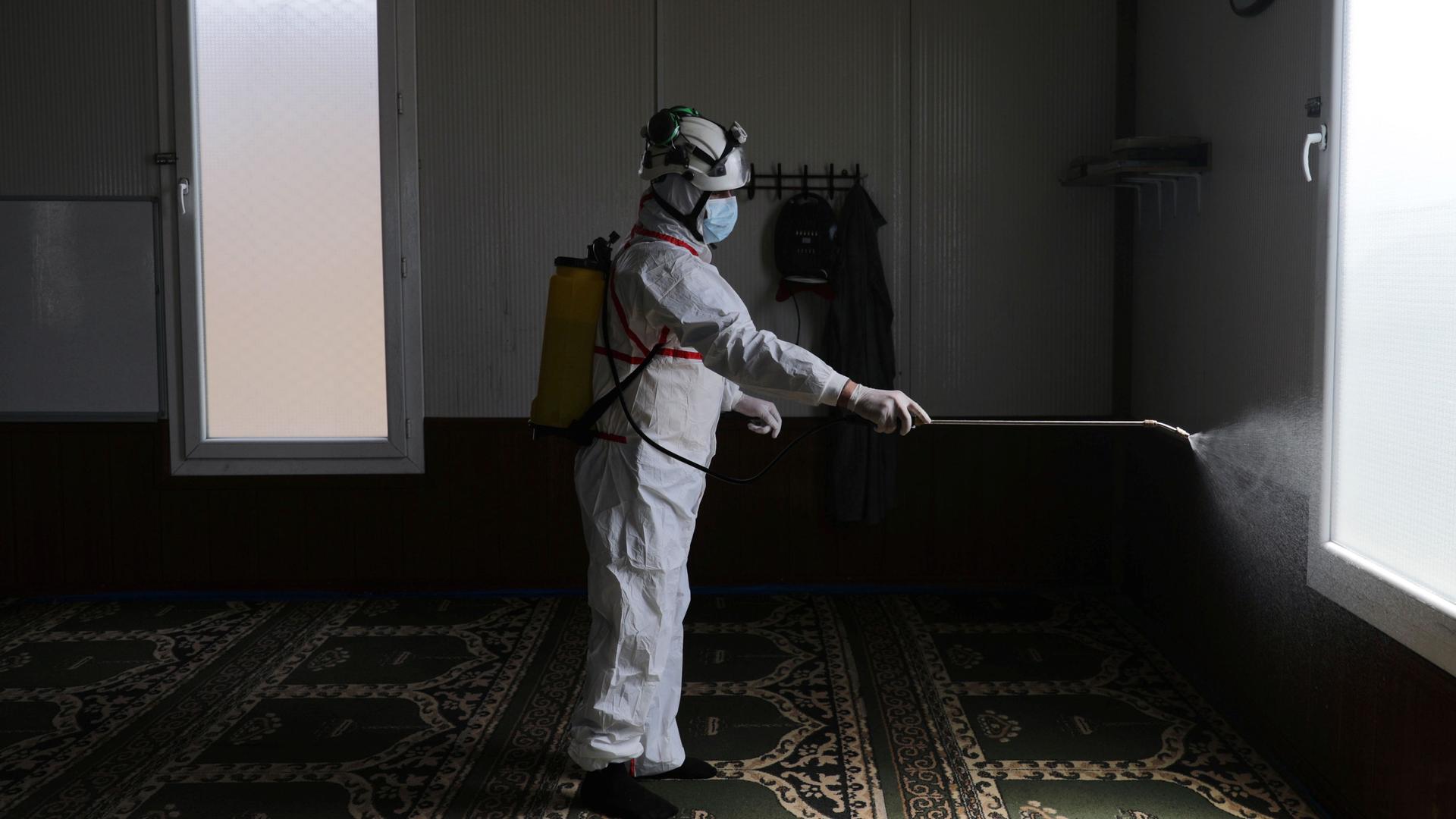 A member of the Syrian Civil Defense sanitizes inside the mosque at the Bab al-Nour internally displaced persons camp, to prevent the spread of the coronavirus disease (COVID-19) in Azaz, Syria, March 26, 2020. 