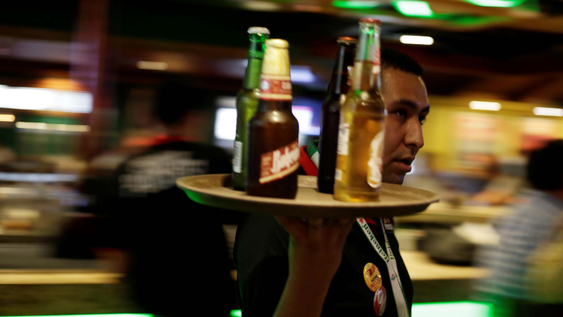 A waiter carries a round tray with bottles of Mexican beer at a bar in Ciudad Juarez, Mexico, on June 20, 2017.
