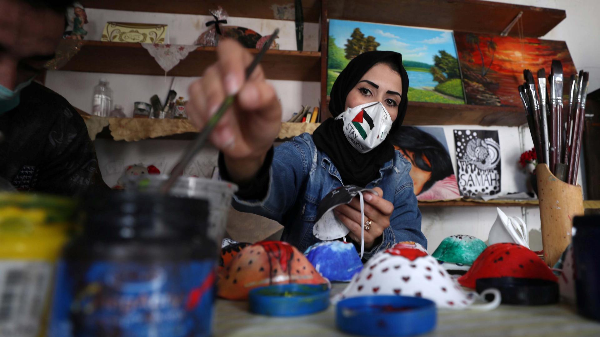 A Palestinian artist paints protective face masks to encourage people to wear them as a precaution against the coronavirus disease (COVID-19), in Gaza City, on March 30, 2020.