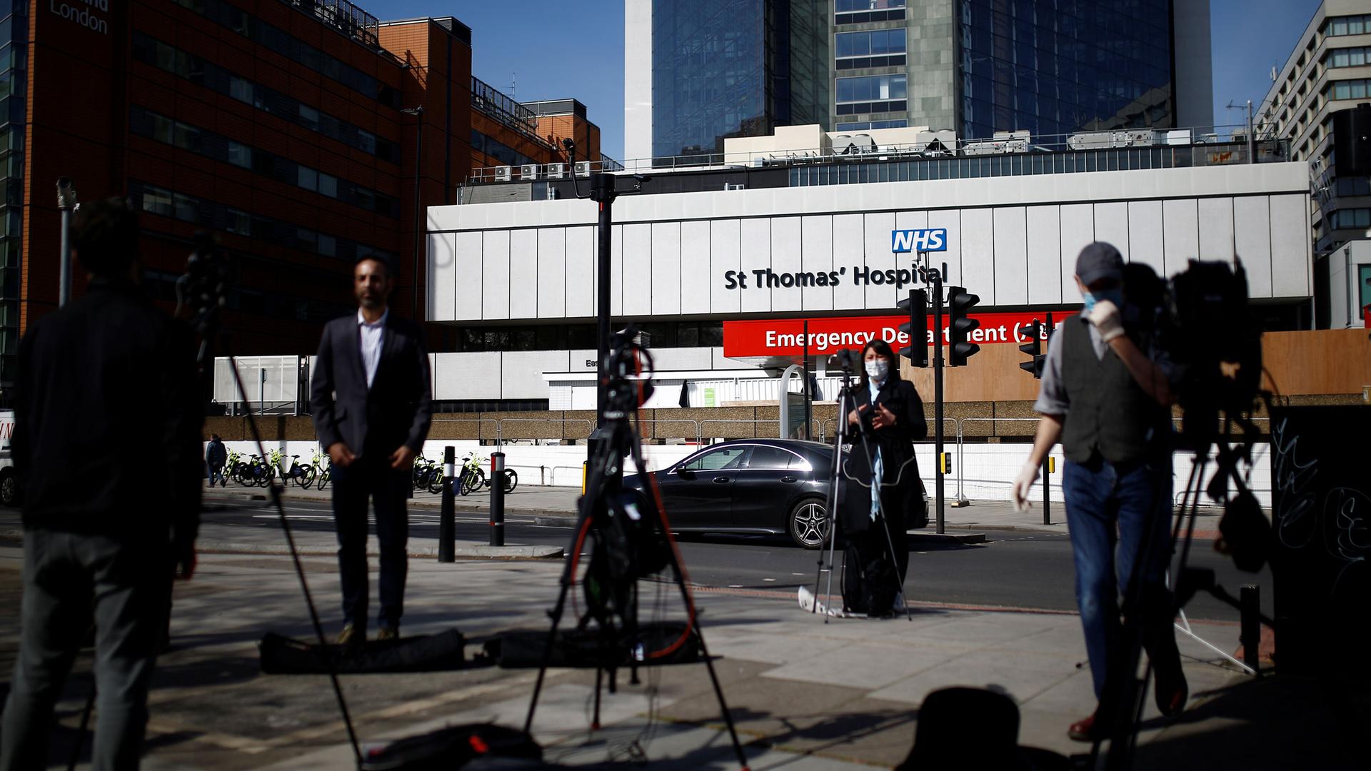 Several television cameras are shown set up with reporters standing in front and St Thomas' Hospital in the background.
