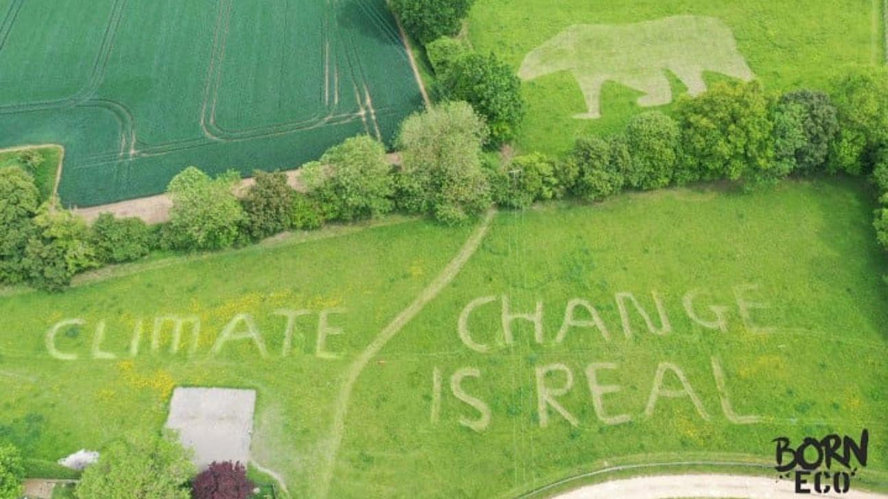 An aerial view of a field with the message "Climate change is real"
