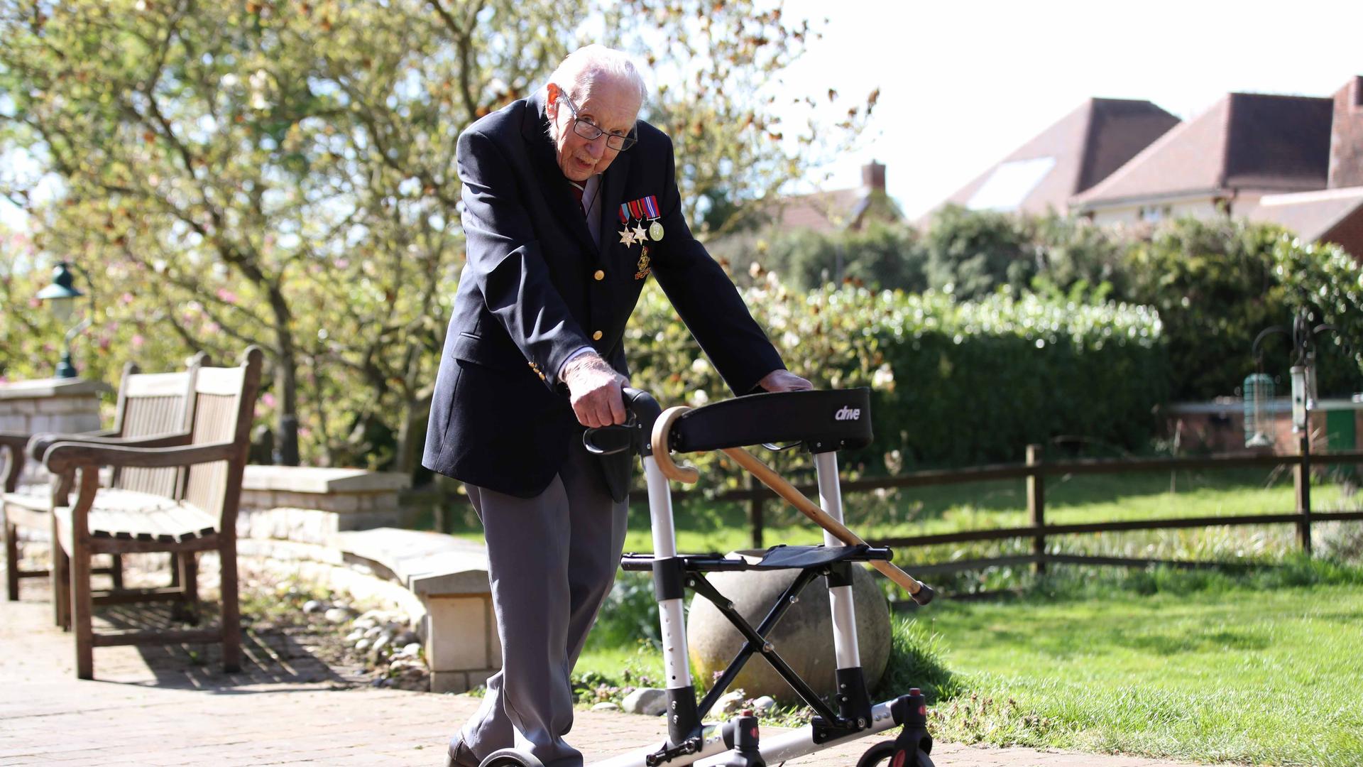 Retired British Army Captain Tom Moore, 99, walks to raise money for health workers, by attempting to walk the length of his garden one hundred times before his 100th birthday this month as the spread of coronavirus disease continues, April 15, 2020. 