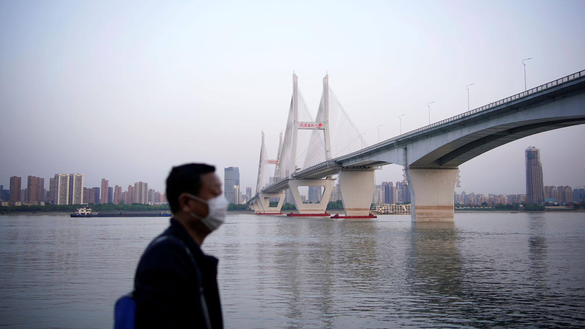 A man wearing a face mask is seen under a bridge of Yangtze river