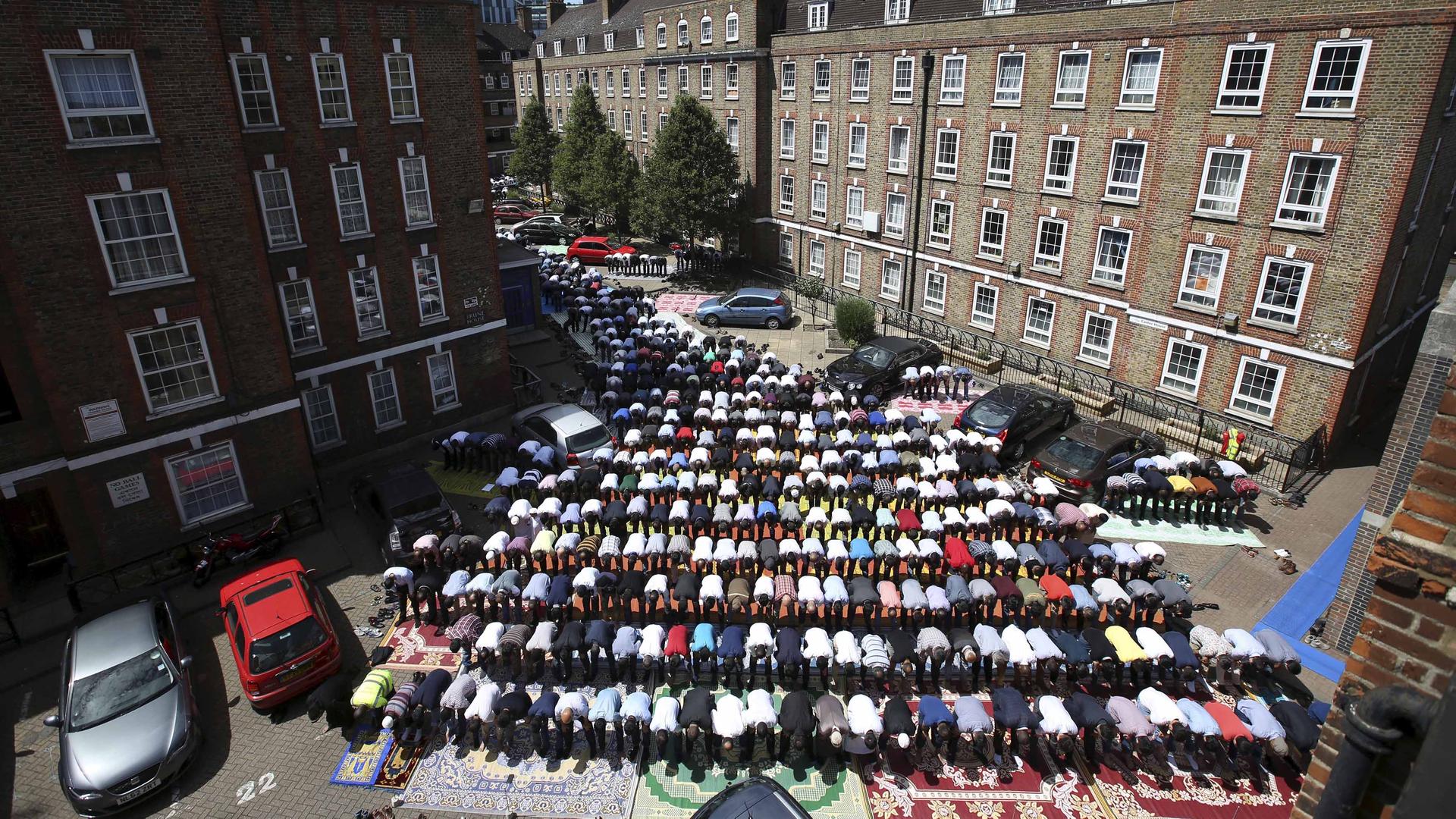 An aerial Muslims attend Friday prayers in the courtyard of a housing estate next to the small BBC community center and mosque in east London, Britain, July 10, 2015. 