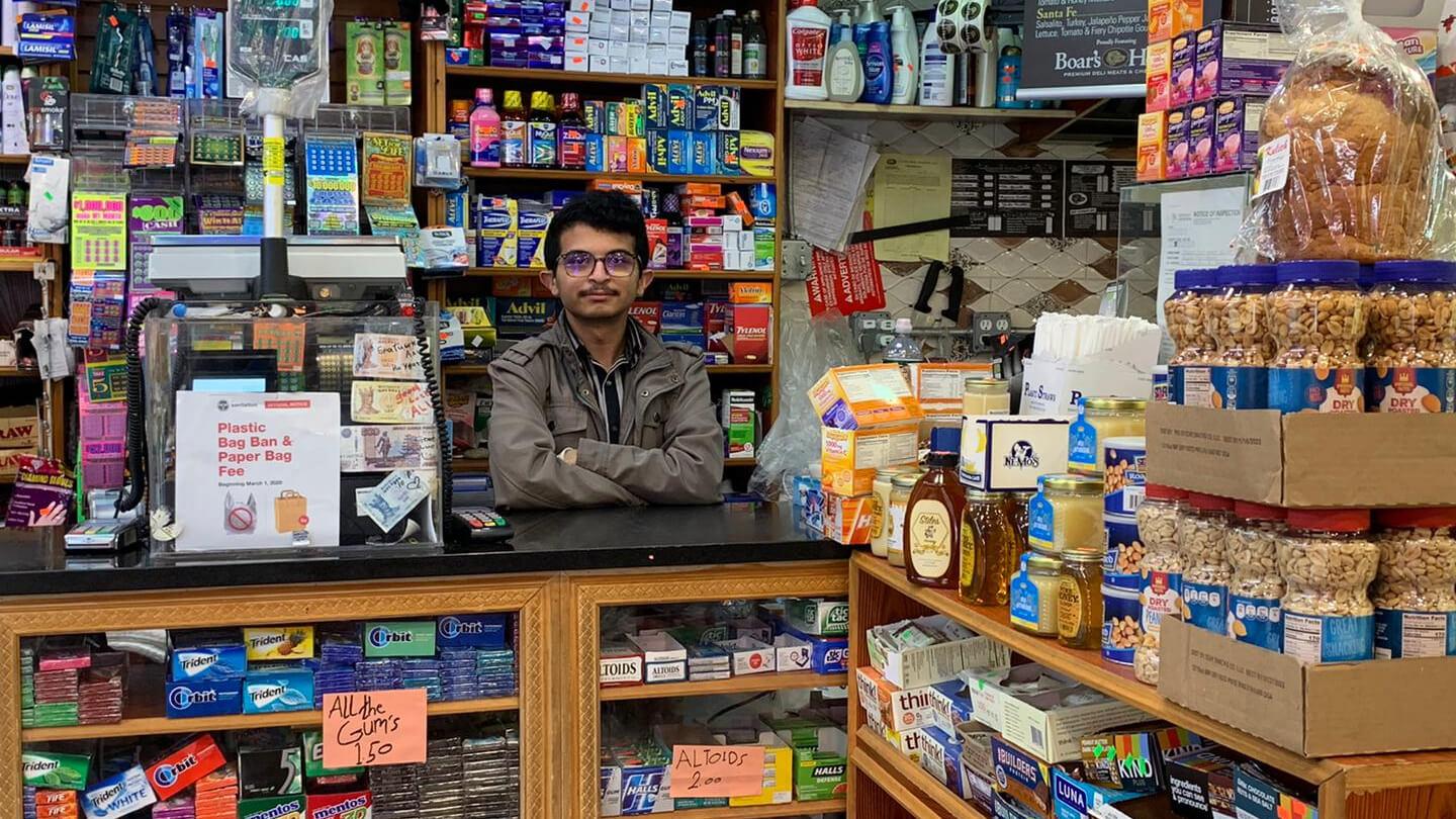 Nasim Almuntaser stands inside his packed bodega filled with products. 