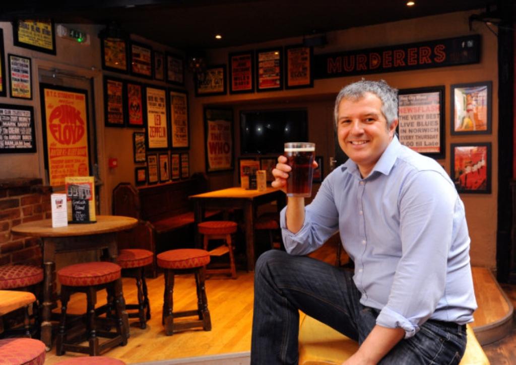 A man enjoys a beer in a pub
