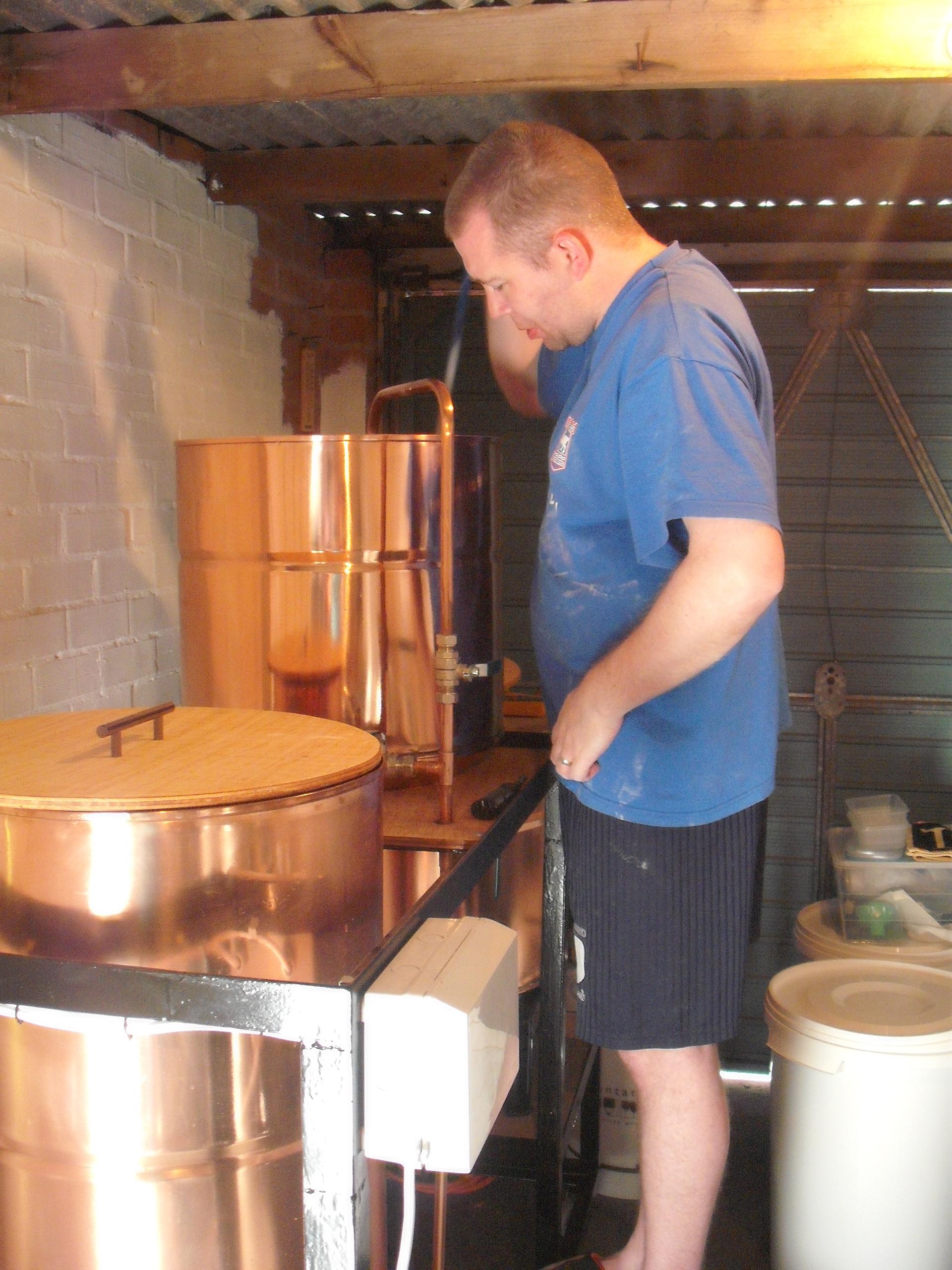 A man stands over a brewer's kit