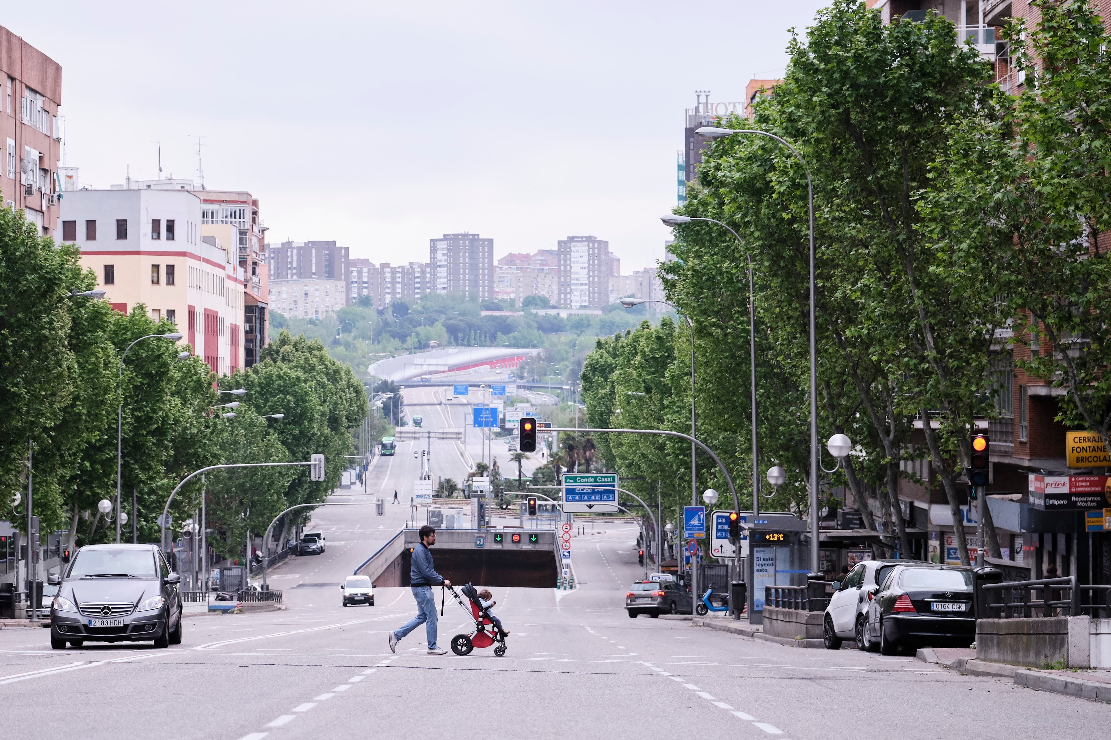 A man walks a baby across the street in a pushchair in Madrid as Spain lifts restrictions on children outdoors due to the coronavirus pandemic.