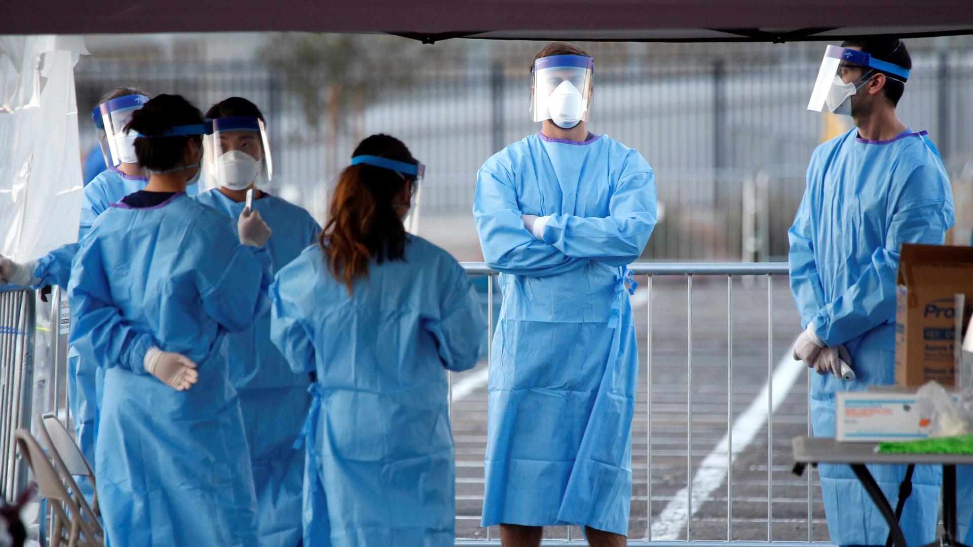 Medical students and physician assistants from Touro University Nevada wait to screen people in a temporary parking lot shelter at Cashman Center, with spaces marked for social distancing to help slow the spread of the coronavirus disease (COVID-19) in La