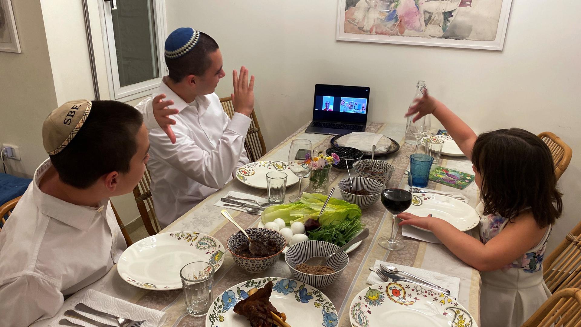 Three siblings in Mevasseret Zion, near Jerusalem, wave to their their grandmother in Haifa as she joins their Passover Seder via Zoom application as Israel takes stringent steps to contain the coronavirus (COVID-19) April 8, 2020. 