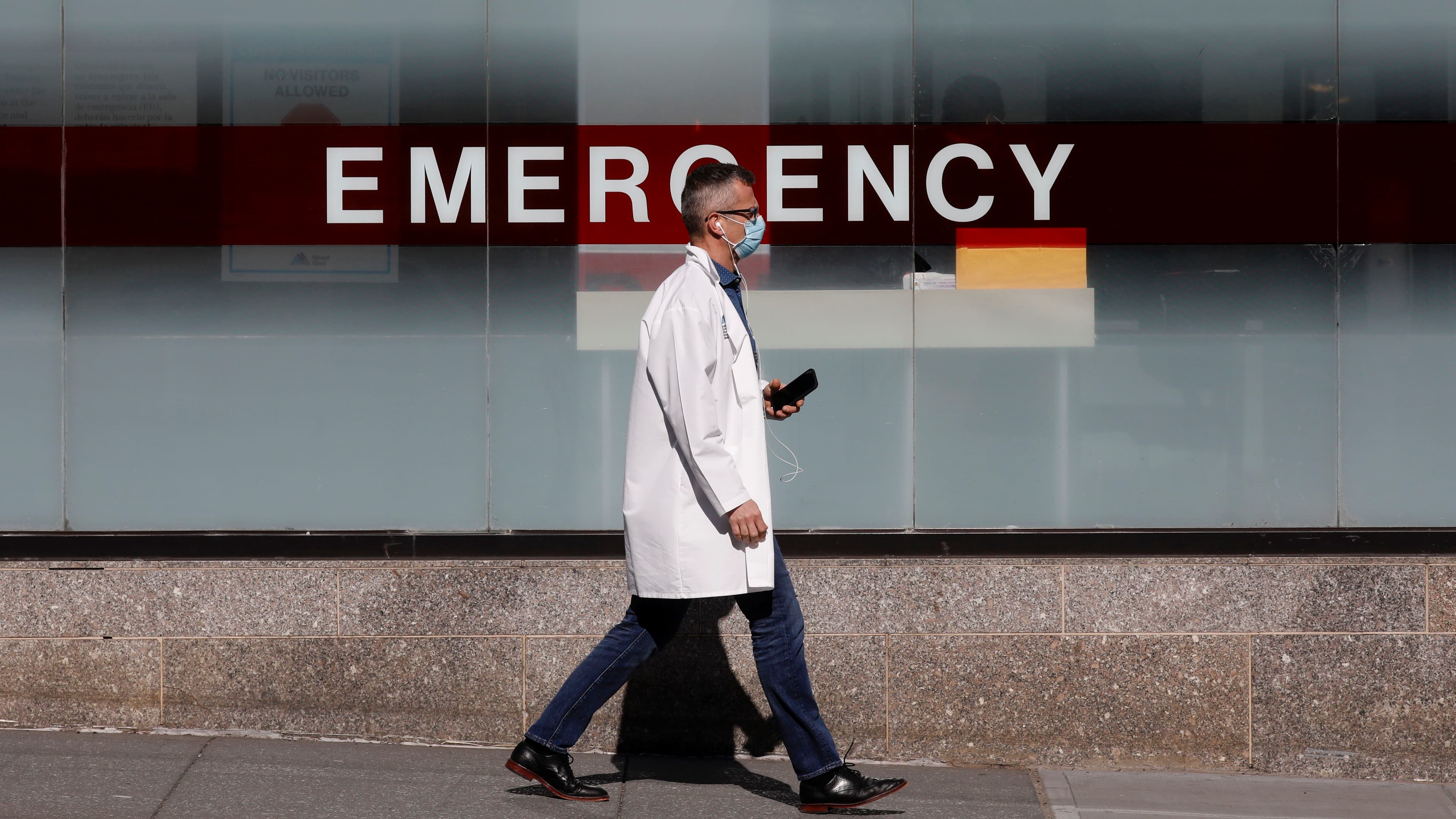 A doctor wears a protective mask as he walks outside Mount Sinai Hospital in Manhattan during the outbreak of the coronavirus disease (COVID-19) in New York, April 1, 2020.